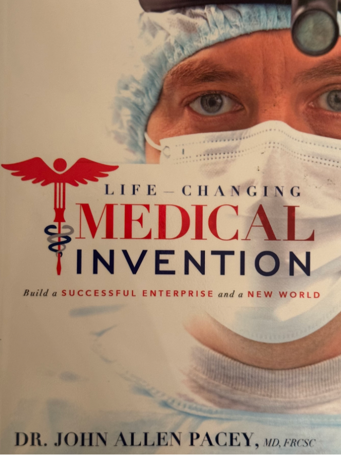 Close-up of a person wearing a surgical mask and a medical cap, with a book cover titled 'Life-Changing Medical Invention' by Dr. John Allen Pacey, featuring a medical symbol with wings and a caduceus.