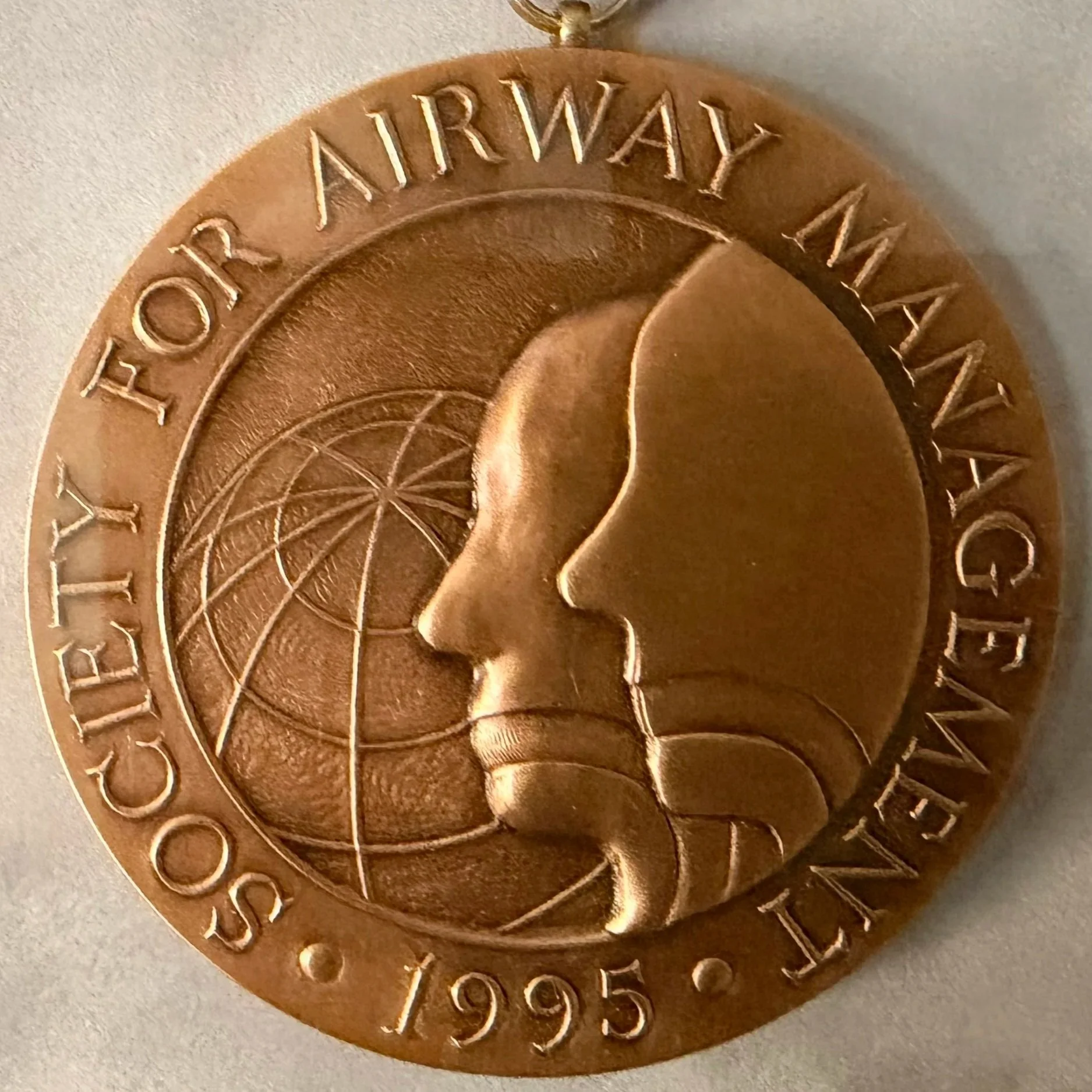 A circular decorative metal piece with the words 'FORT AIRWAY, TX' and the number '925' engraved on it, featuring a central star design.