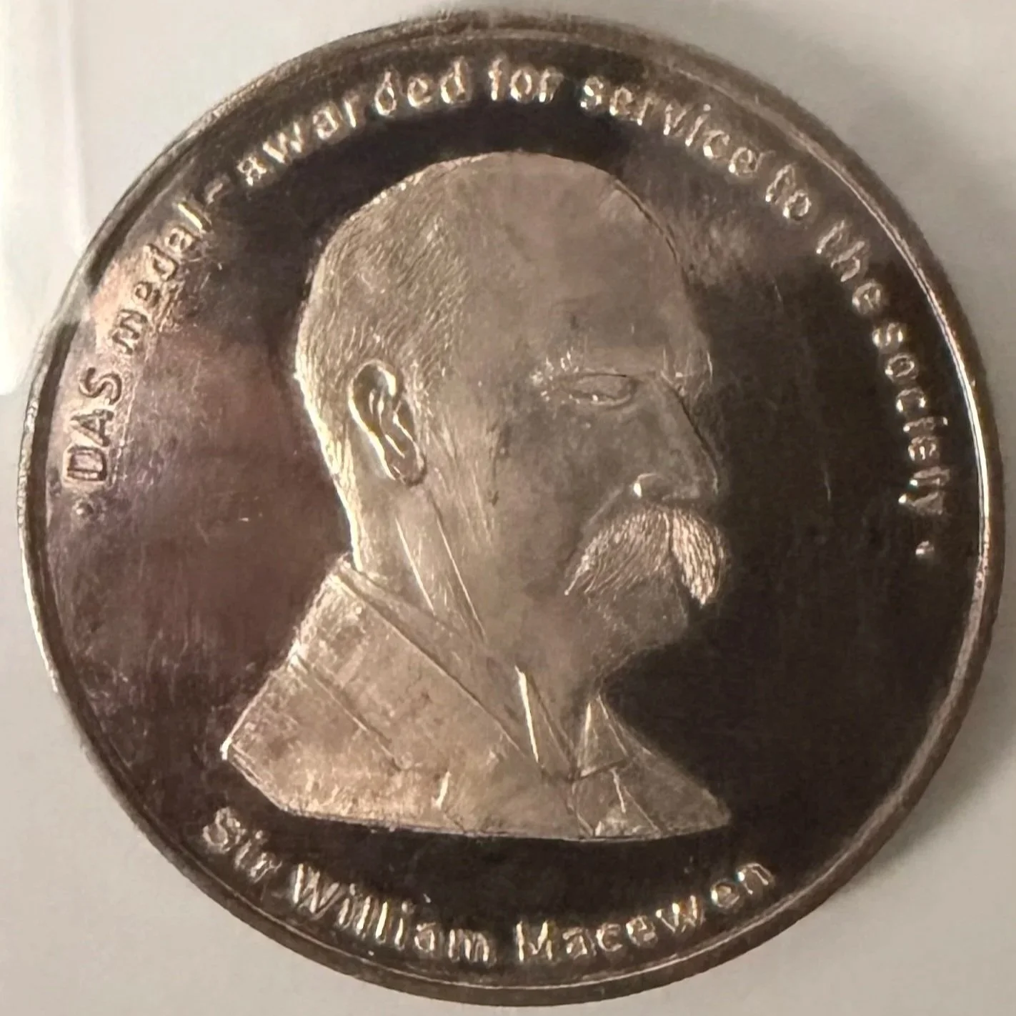 Close-up of a United States quarter coin featuring the profile of a man with a mustache and beard, with inscriptions around the edge.