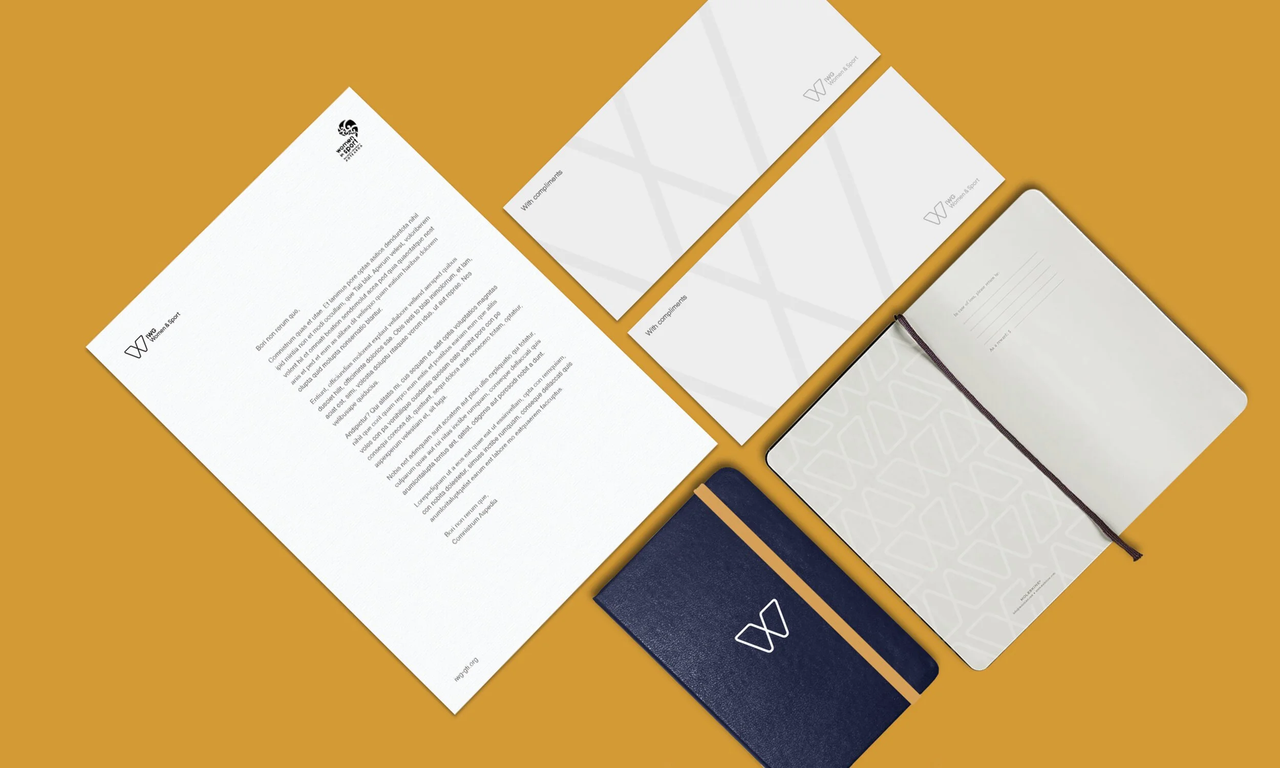 Multiple stationery items including letterhead, business cards, notebooks, and a pen arranged on a mustard-colored background.
