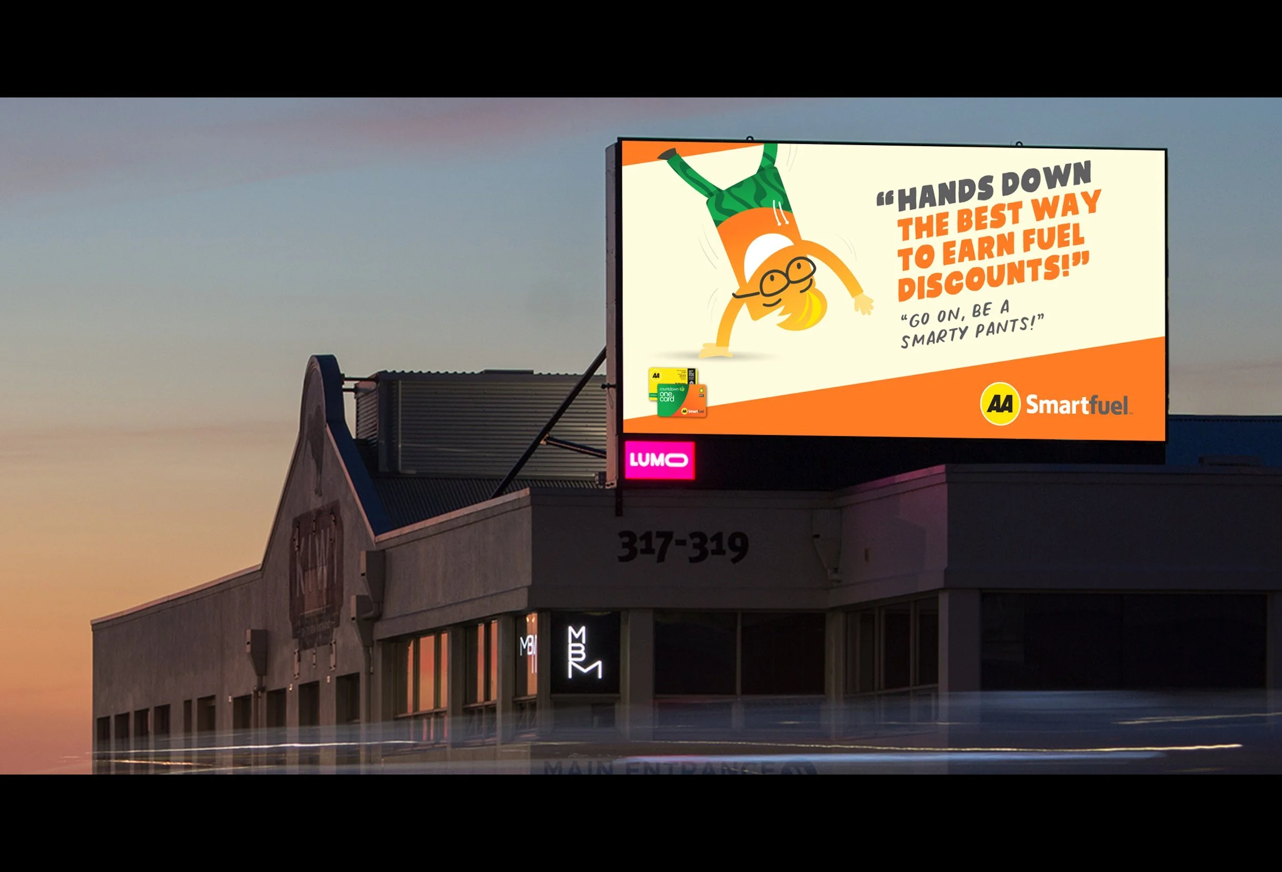 Billboard advertising AA Smartfuel with a cartoon character performing a handstand, wearing glasses, an orange and green outfit, and saying "Hands Down the Best Way to Earn Fuel Discounts!"