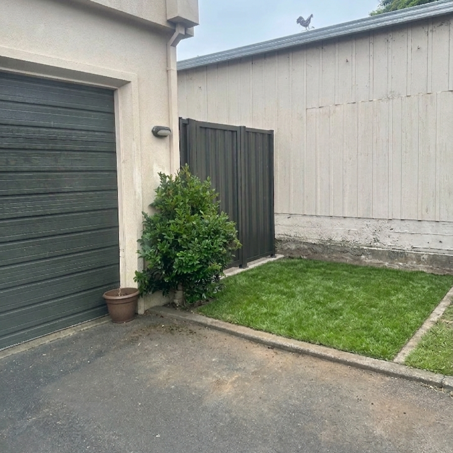 An example of a colour steel gate with grass area in front.