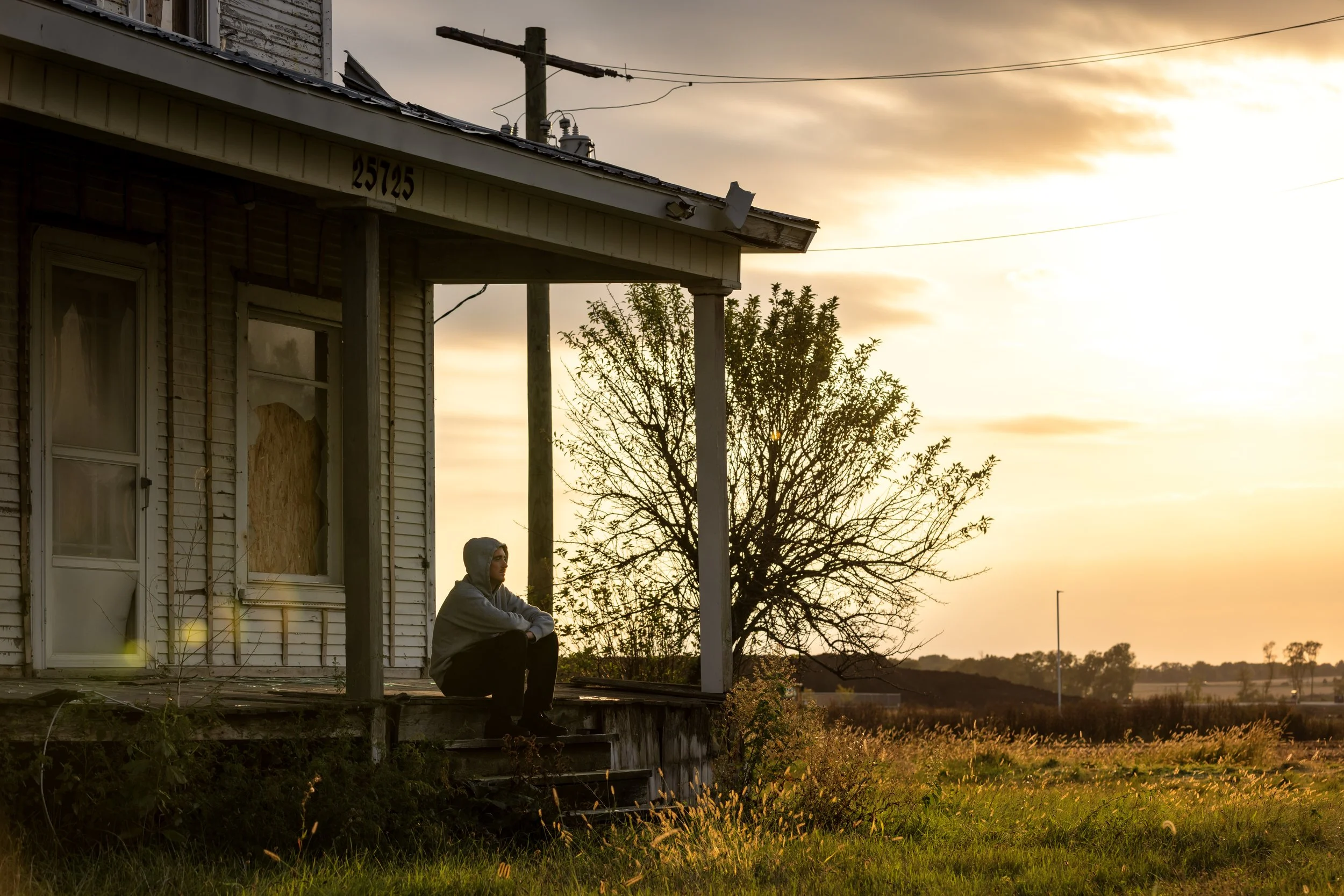 Tyler sitting on abandoned house sunset portrait 2.JPG