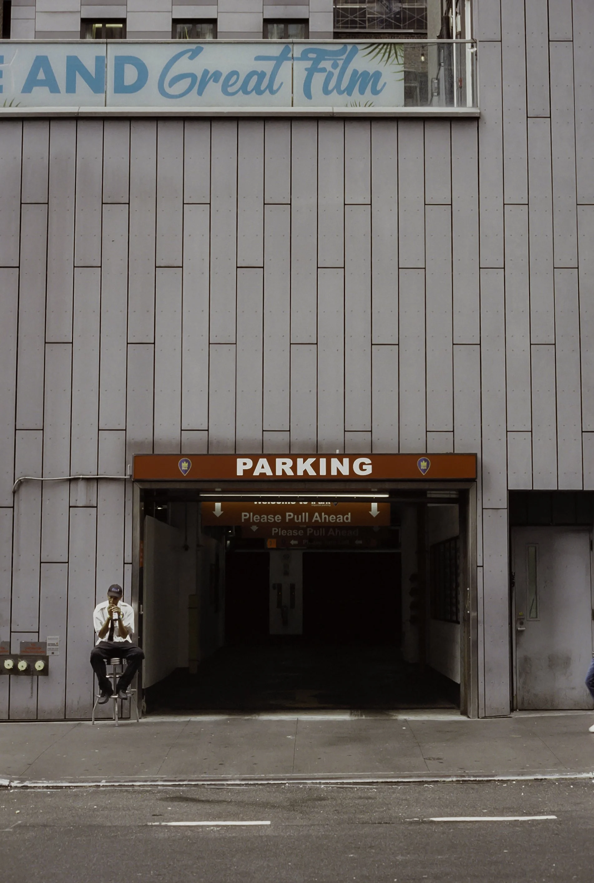 Guy sitting in front of parking garage.JPG