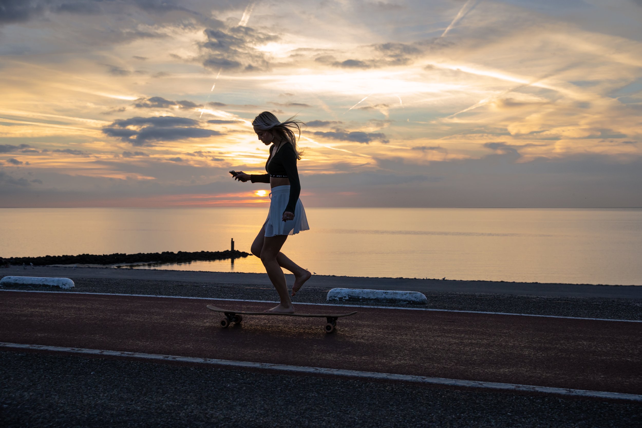 Sterre longboarding by beach at sunset 6.JPG