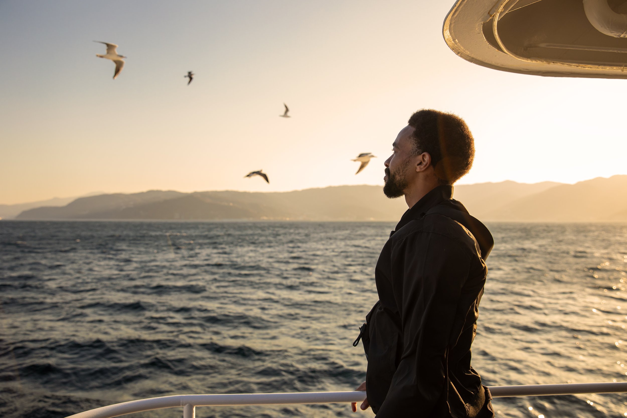 Timmy on boat looking out at ocean portrait.JPG