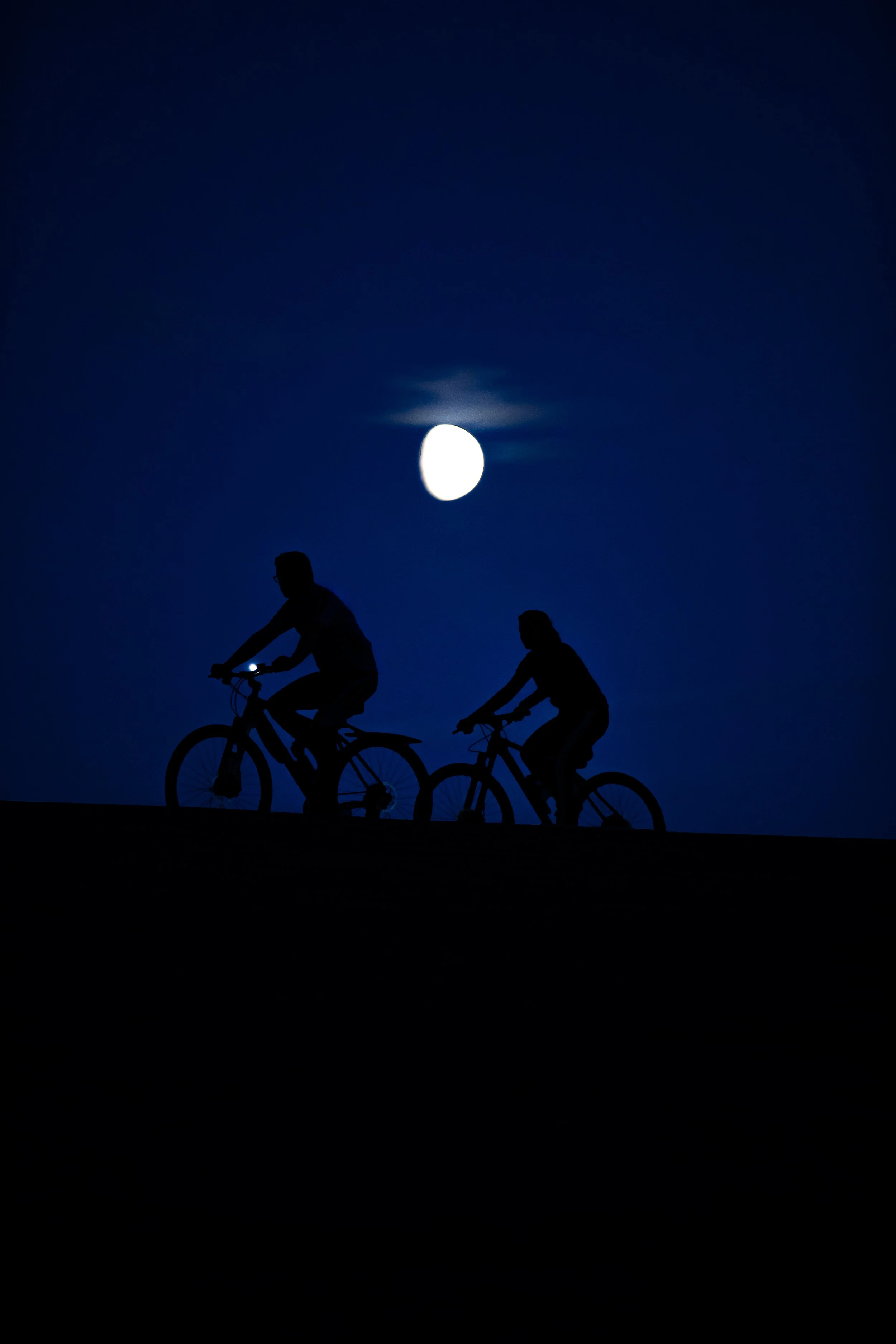 Bikers riding on hill under moon.JPG
