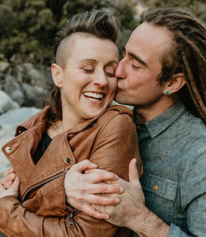Romantic couple man hugging from the back kissing on cheek