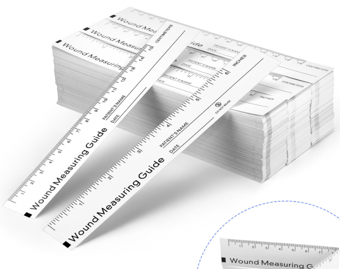 Multiple wound measuring guides and rulers stacked, with one ruler extending outward, used for measuring wounds.
