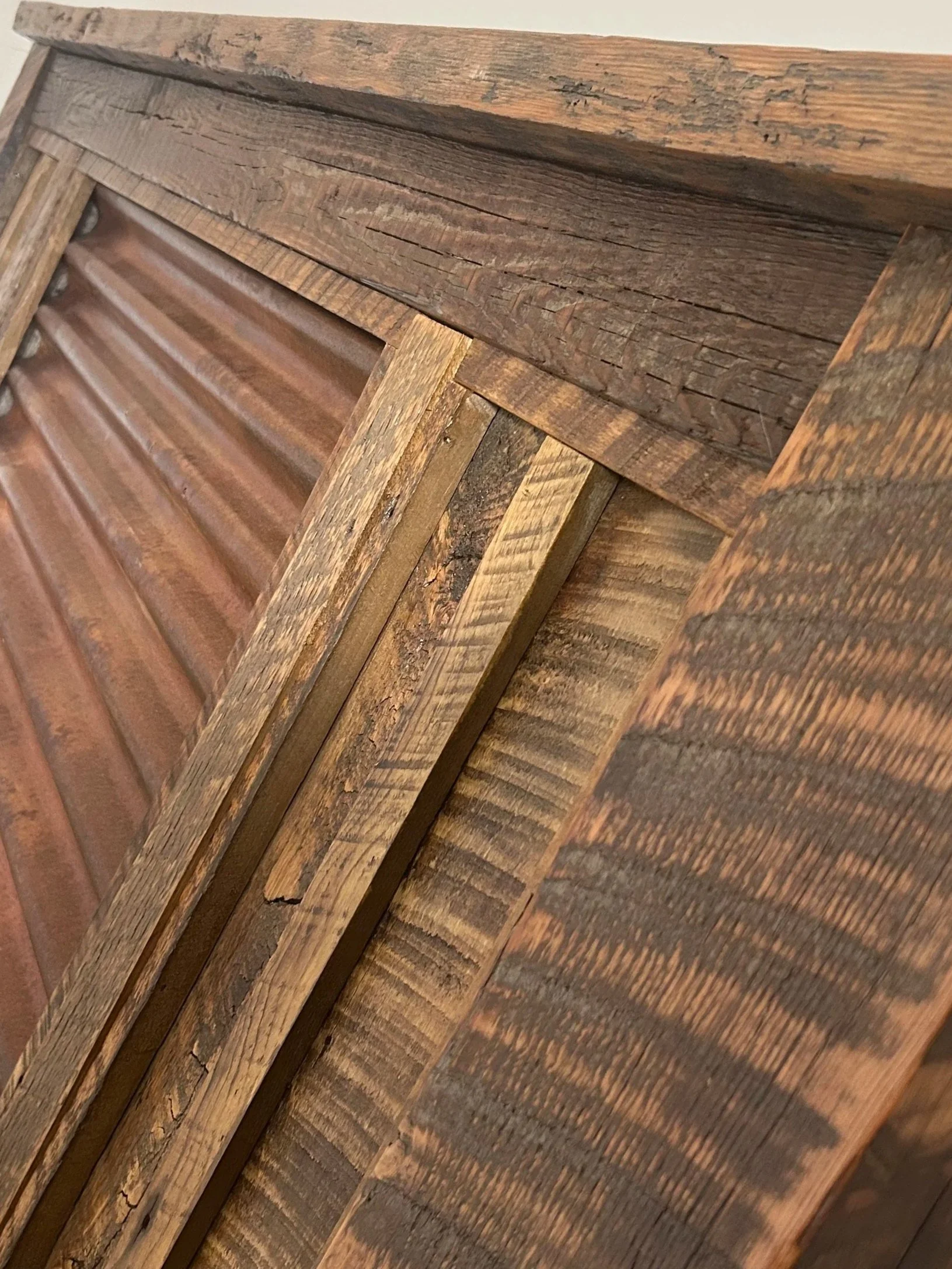 Close-up of a stacked wooden surface, showing various textured and weathered wood planks and panels.