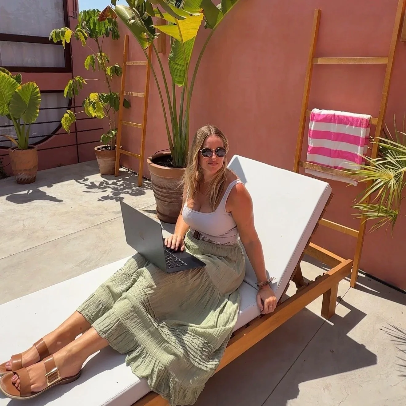 Megan working remotely with her laptop on a sunbed in Puerto Escondido, Mexico