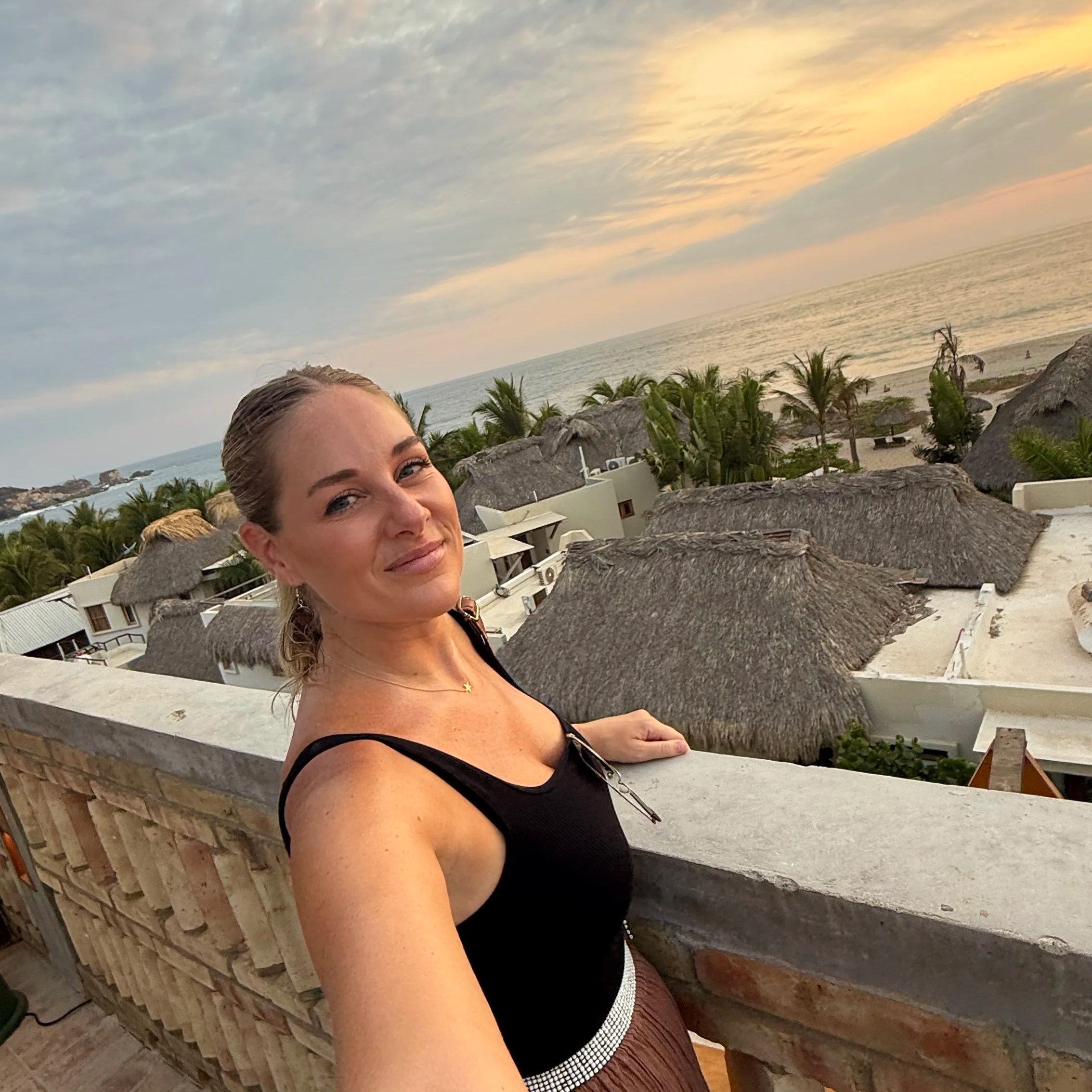 Megan in Puerto Escondido Mexico watching the sunset over the Pacific Ocean from the rooftop of Hotel Humano