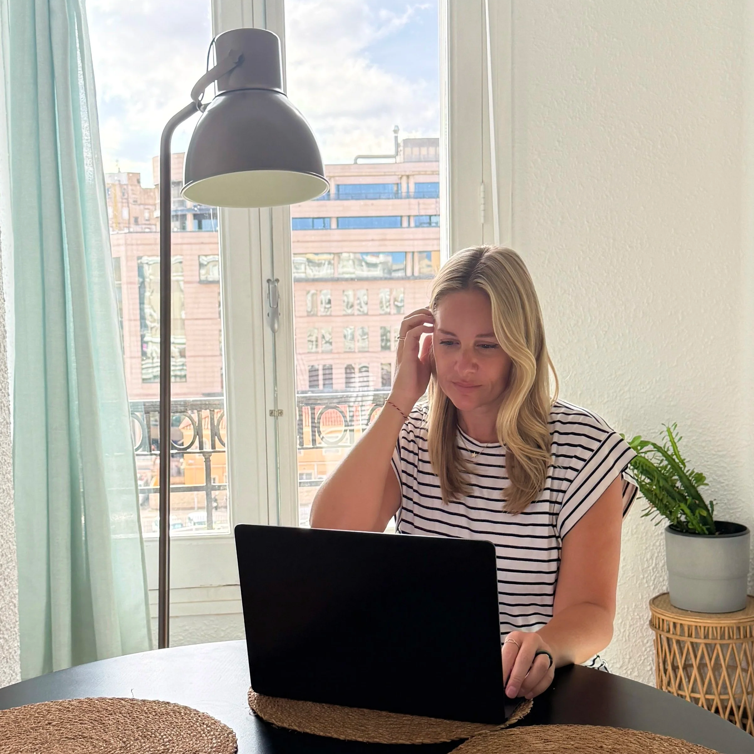 Megan sitting at a dining table working with a laptop at Folks Coliving in Valencia, Spain