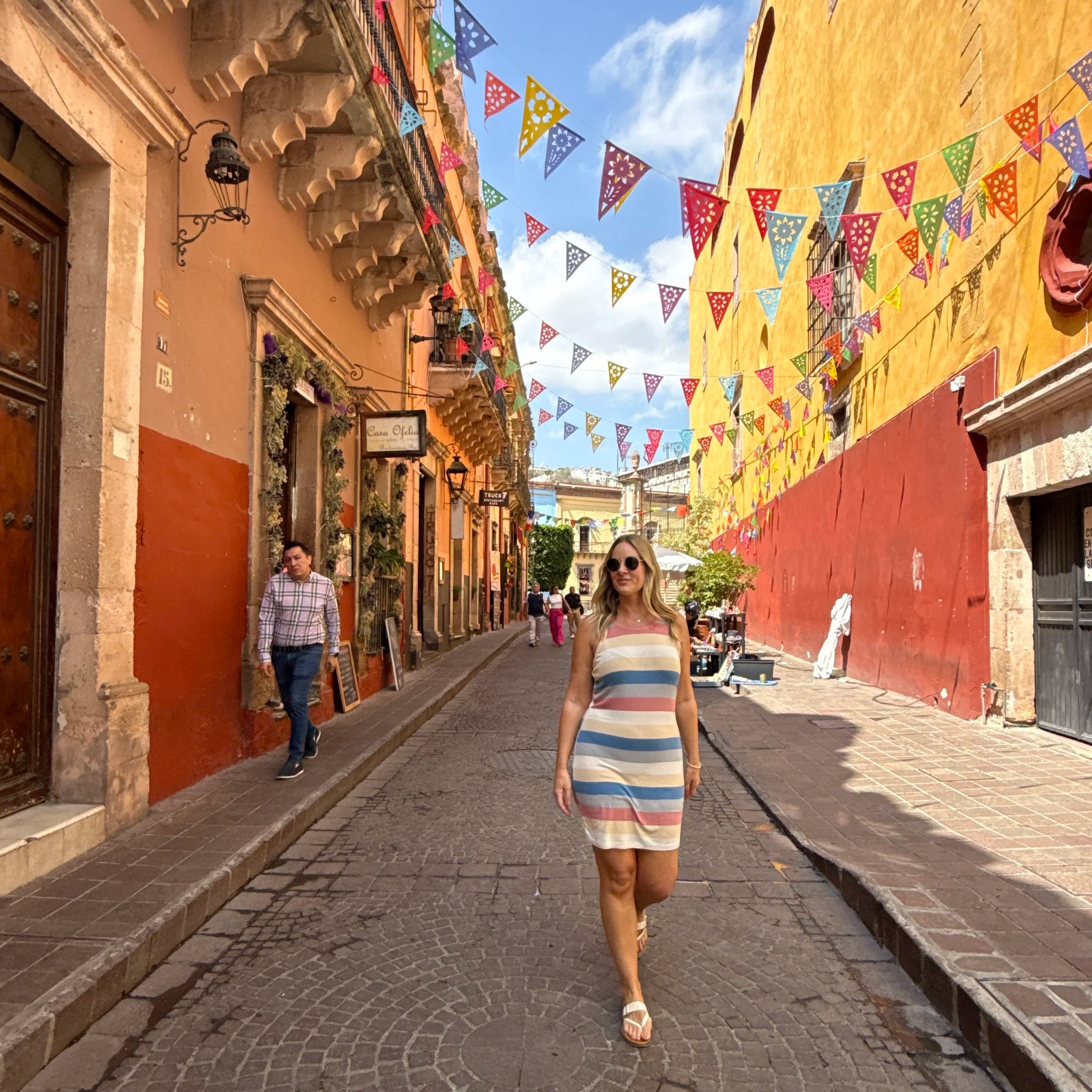 Woman walking down the colorful cobblestone street in Guanajuato, Mexico