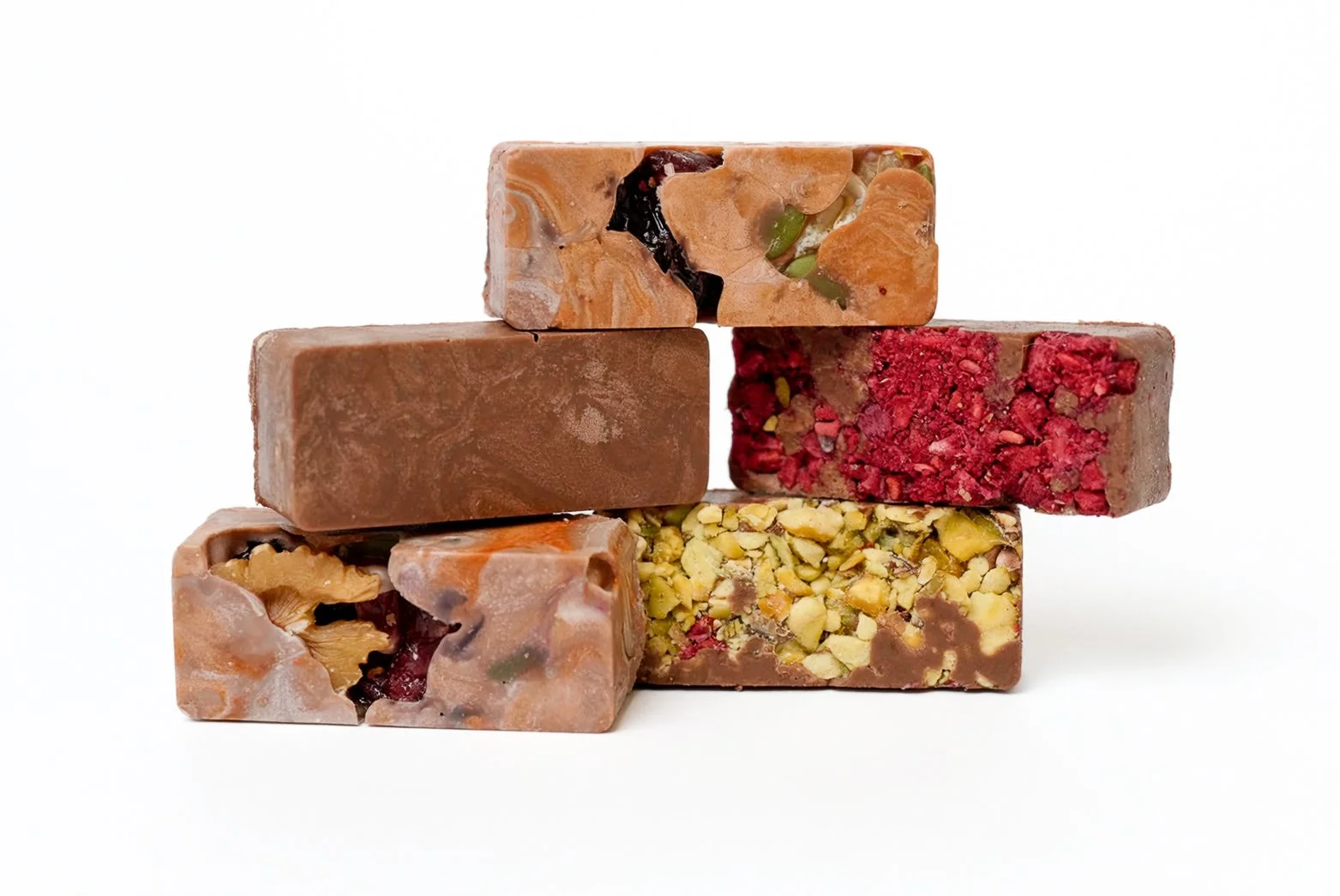 A stack of five assorted handmade chocolates with different textures and ingredients, set against a plain white background.