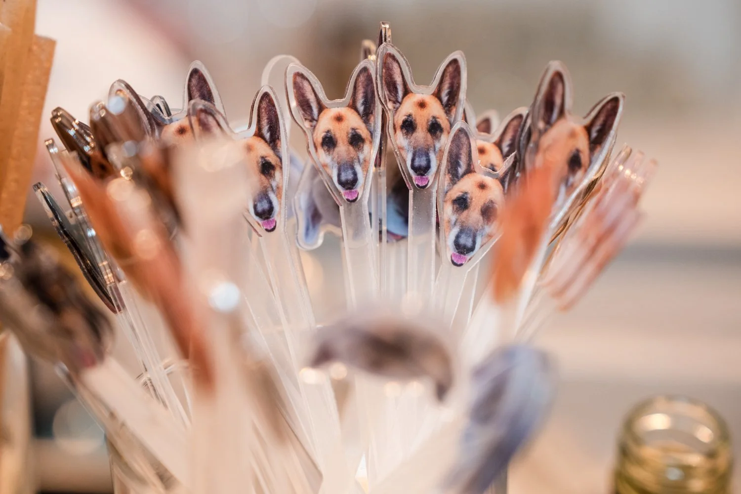 Pens with dog face stickers attached to the top, resembling a German Shepherd, arranged in a container.