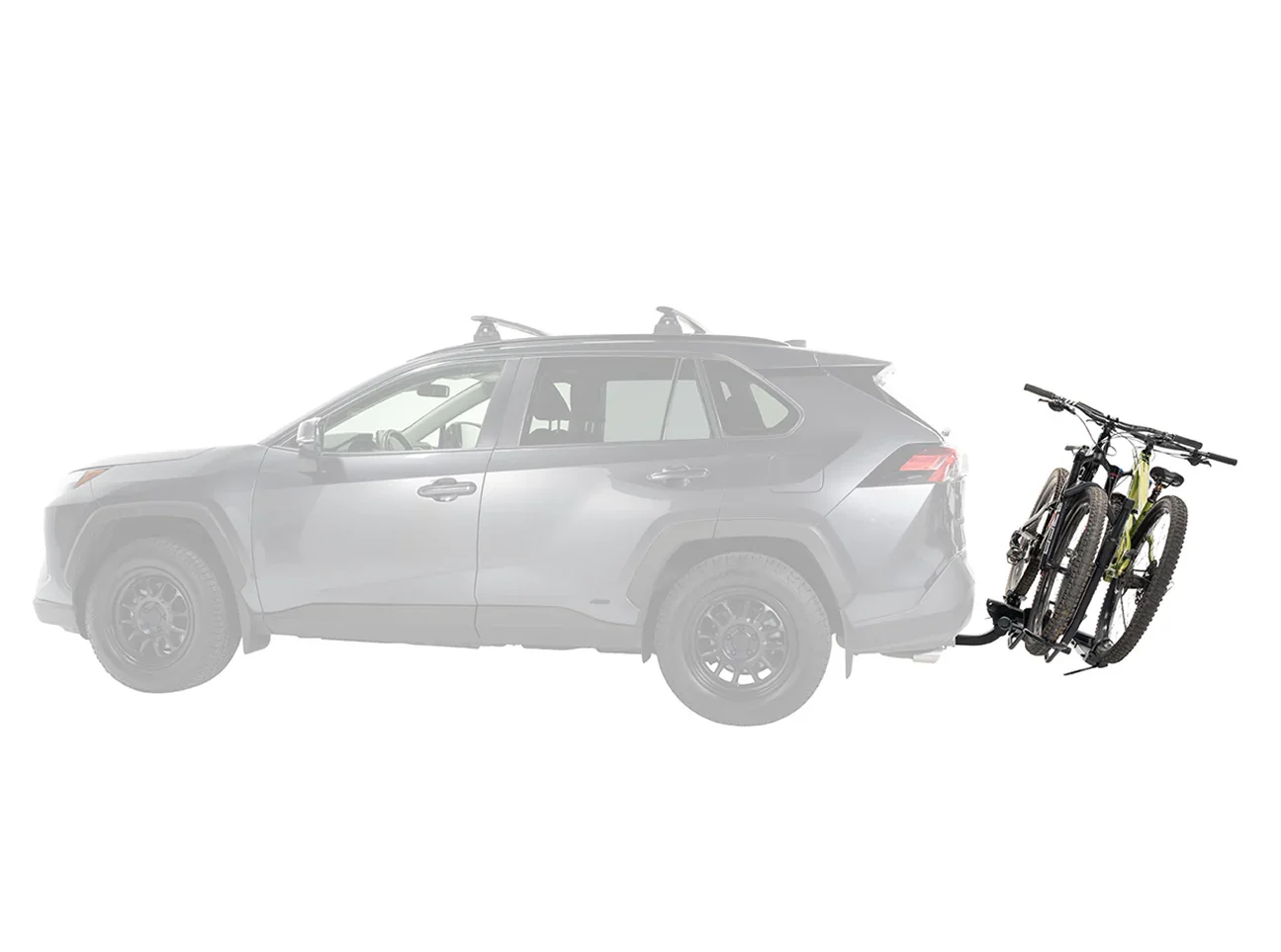 Grey SUV with a Yakima bicycle rack attached, carrying two mountain bikes.