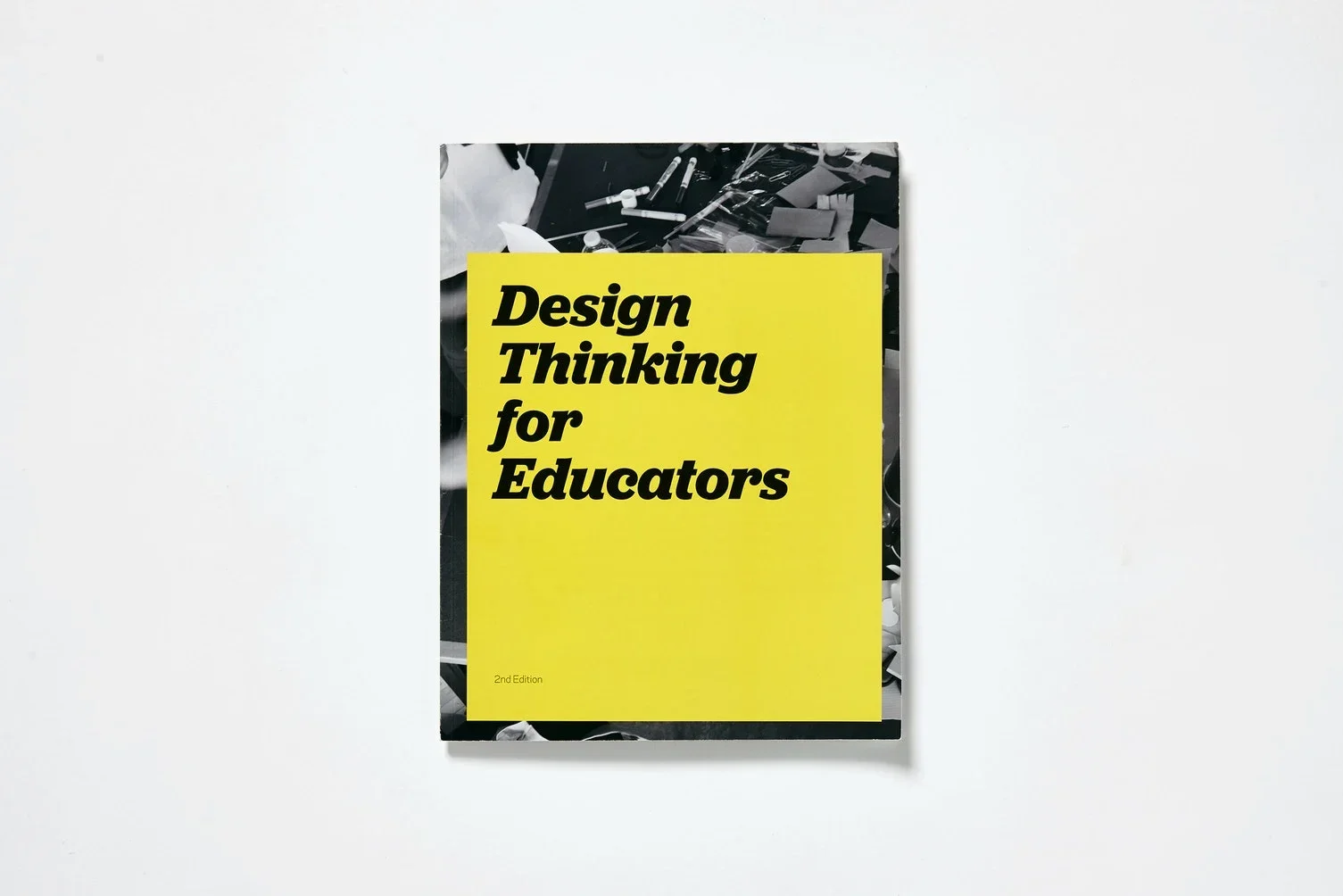 IDEO Book titled 'Design Thinking for Educators' with a bright yellow cover and black bold text, placed on a white surface.