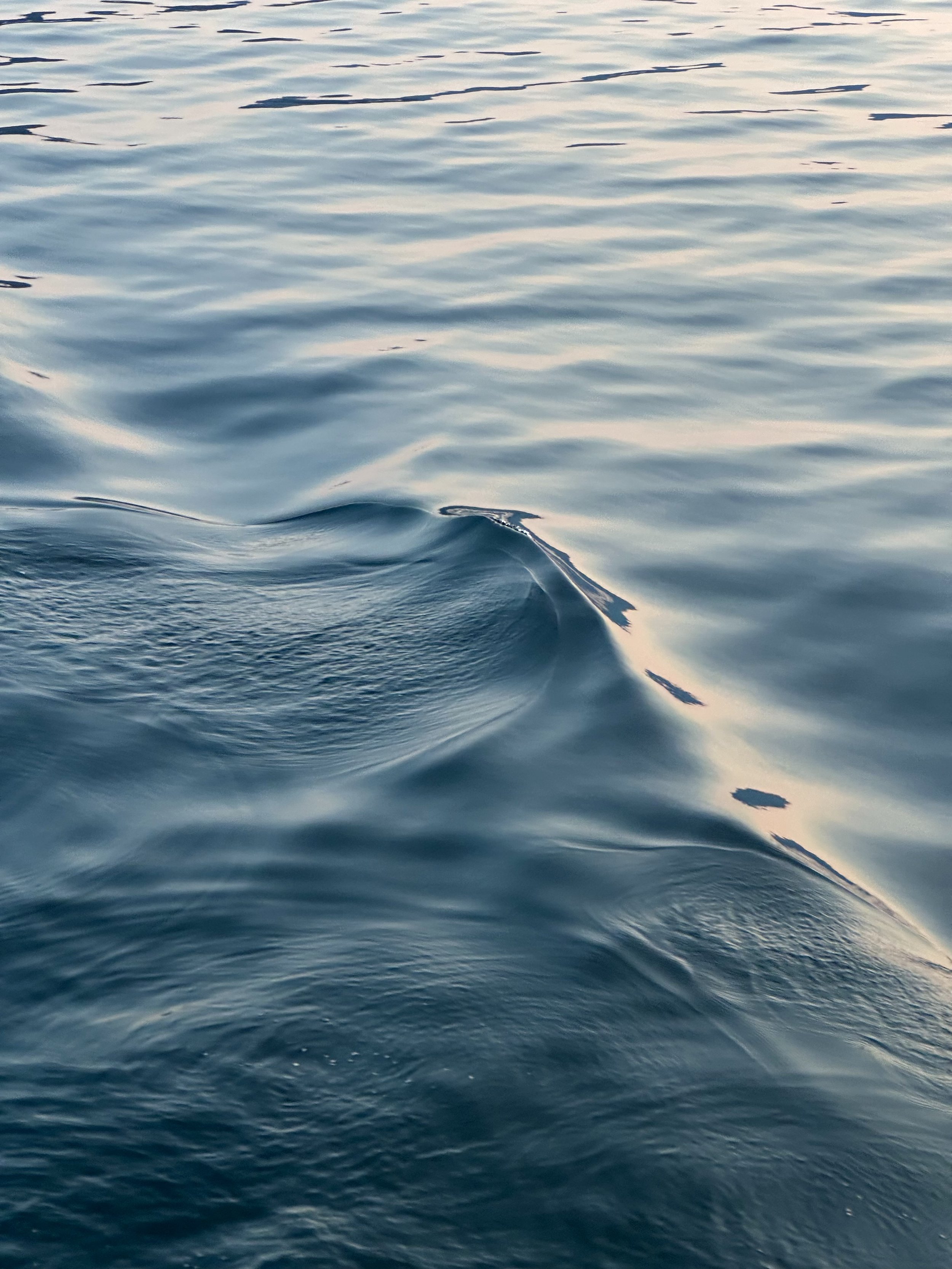 Calm ocean water with gentle ripples and reflections of the sky.