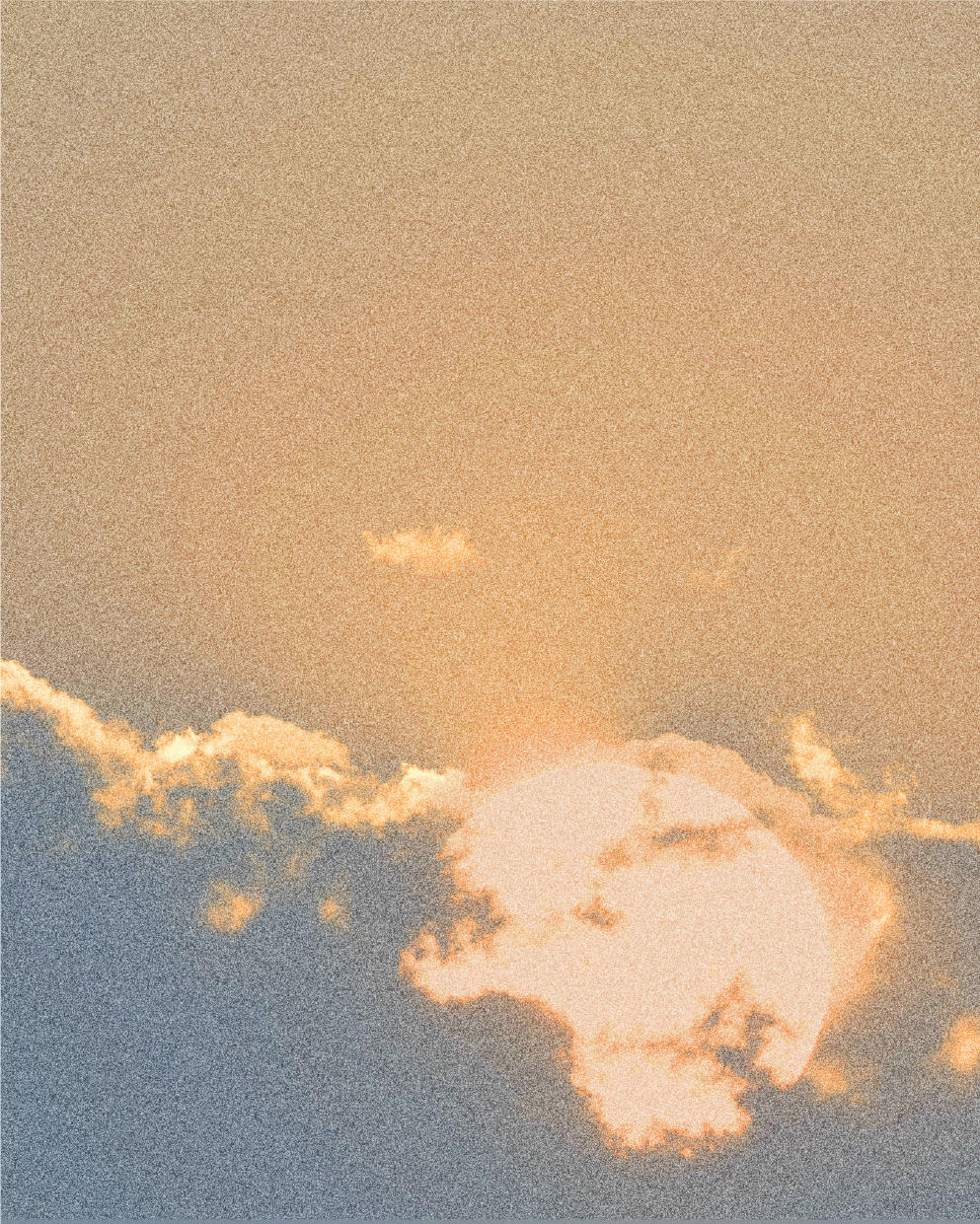 Sunset sky with clouds glowing orange and yellow.