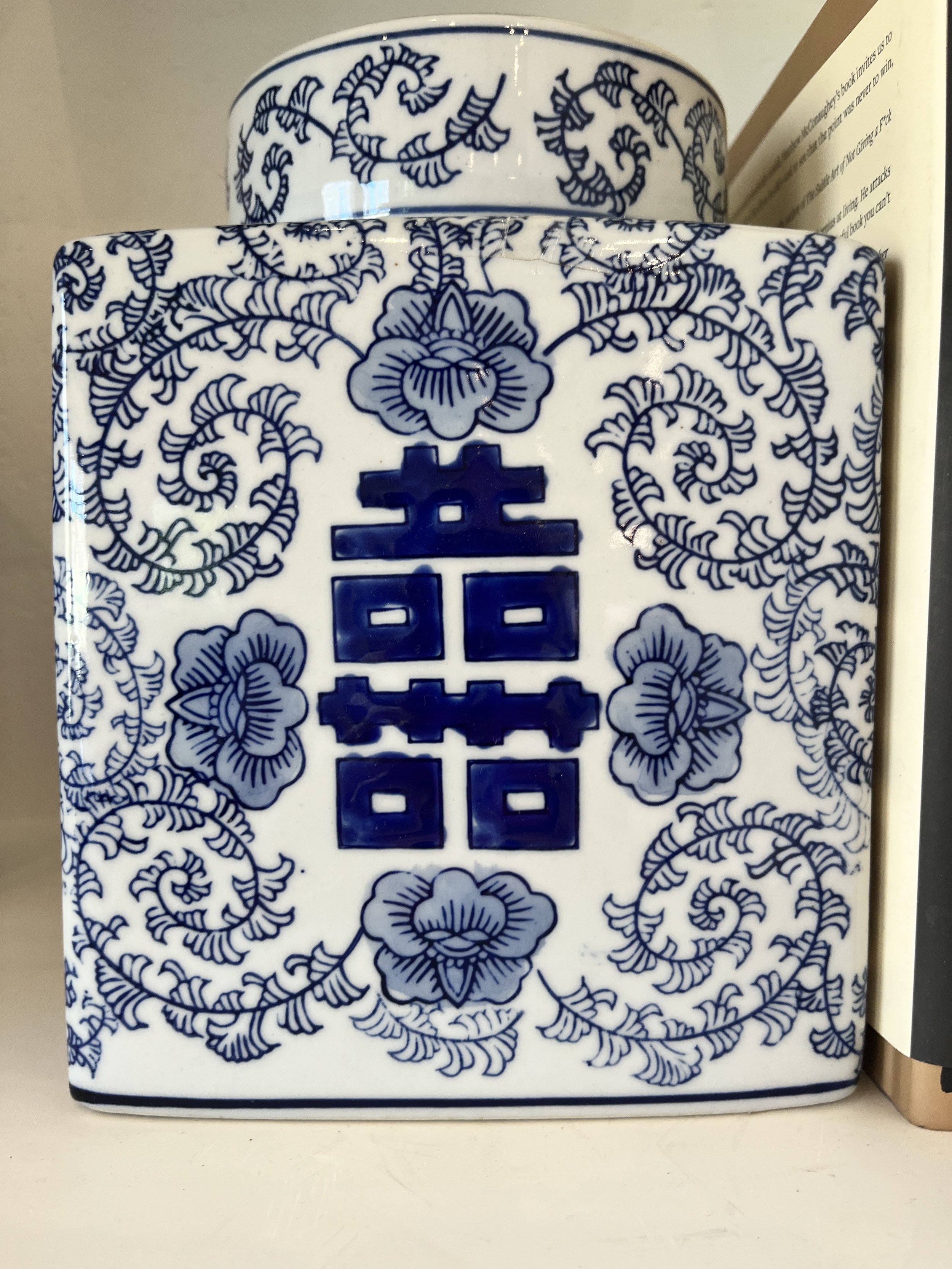 Blue and white porcelain vase with floral and scroll patterns and Chinese characters.