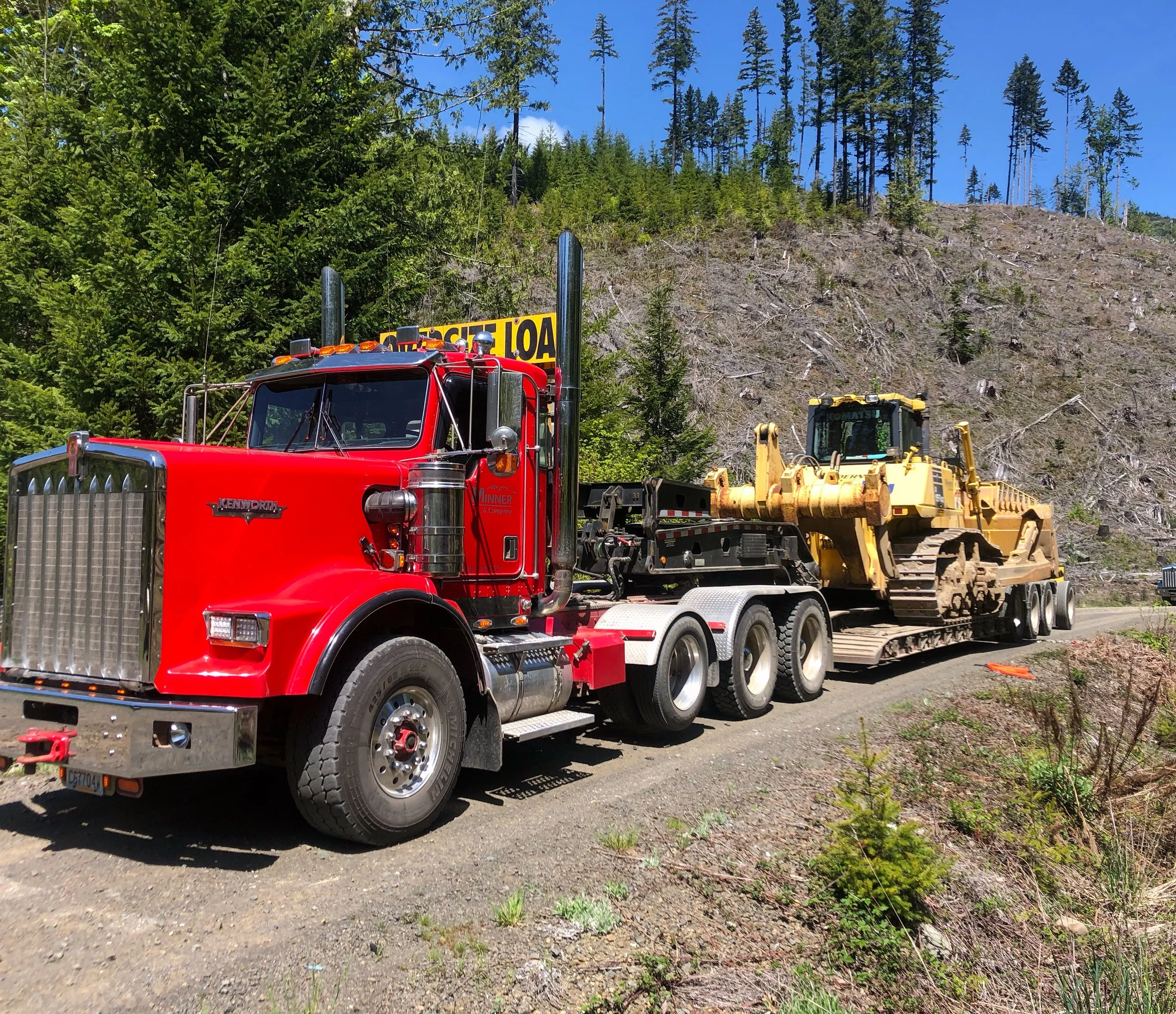 Minner and Company Low Bed hauling equipment on timberland road job