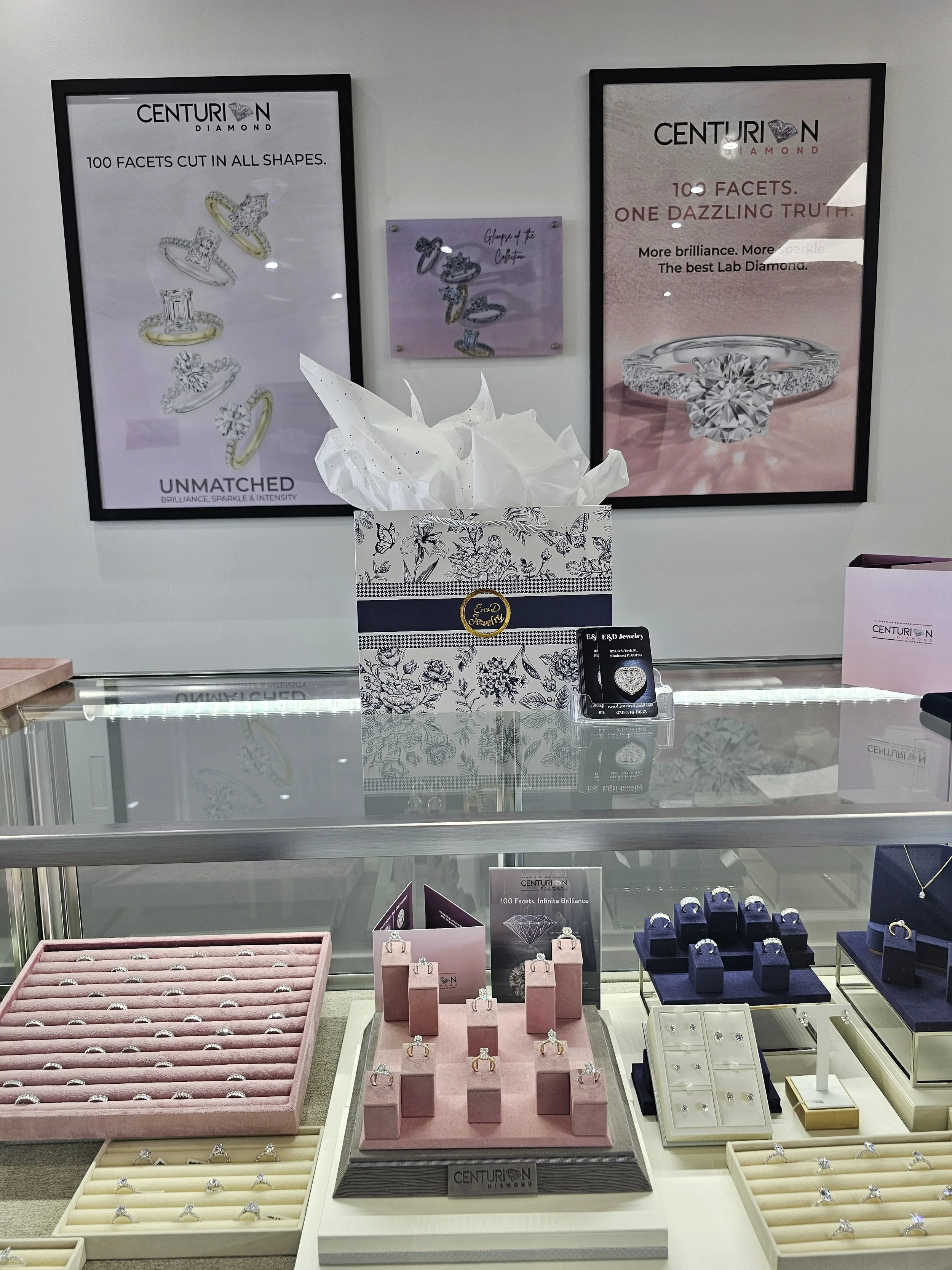 Display case with various diamond rings and earrings. Posters on the wall showcasing diamond jewelry and the brand 'Centurion Diamond'.