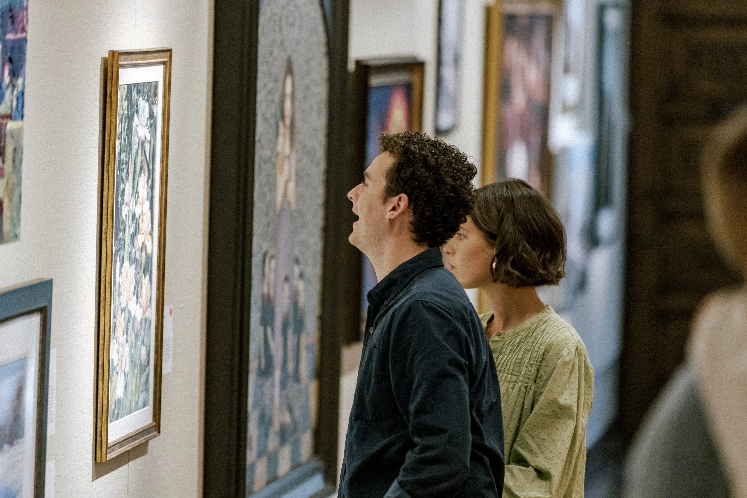 People observing artwork in an art gallery.