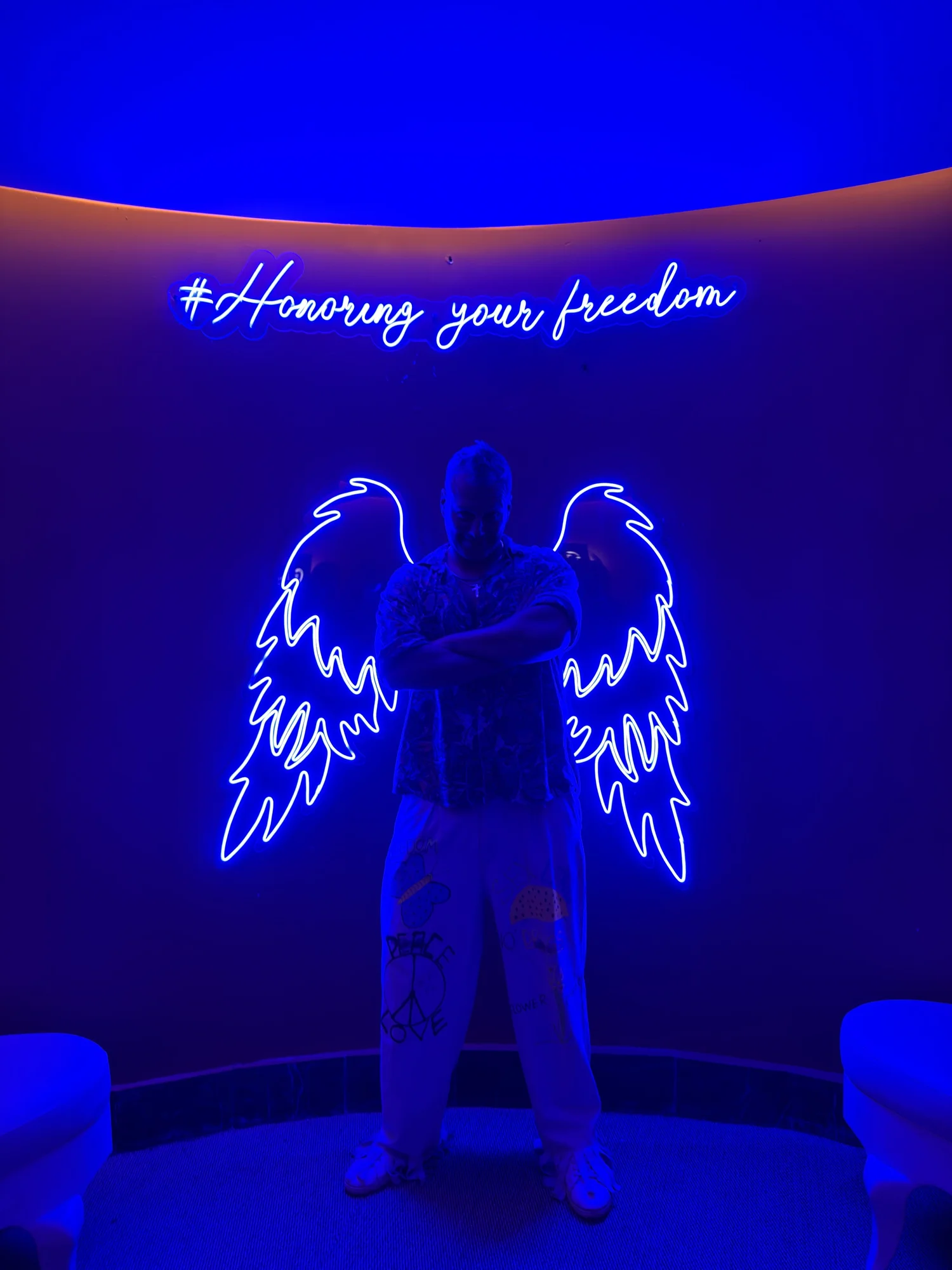 Patrick Gaudet under a neon angel-wings installation