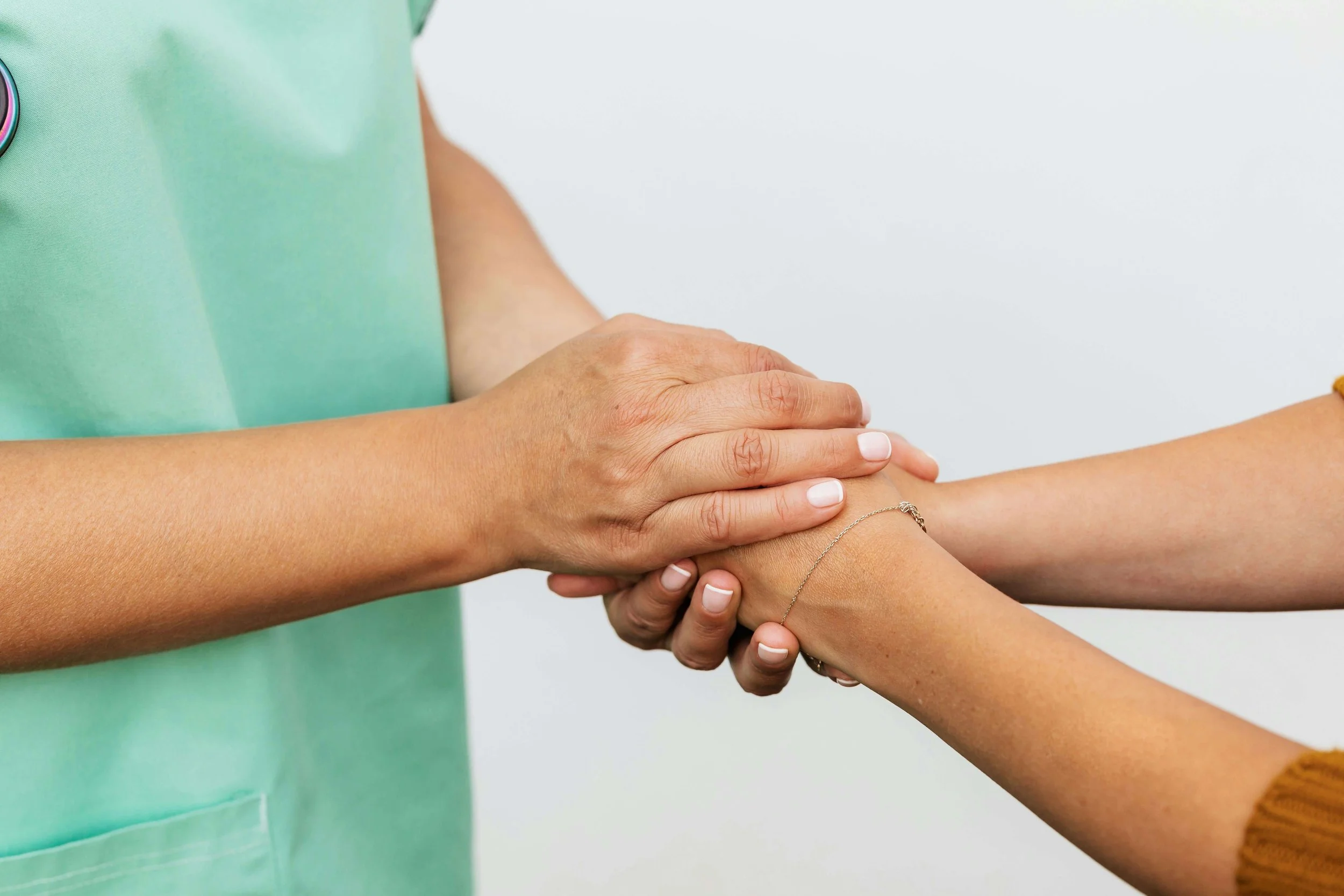 Hands of healthcare worker holding hands of disability services customer.