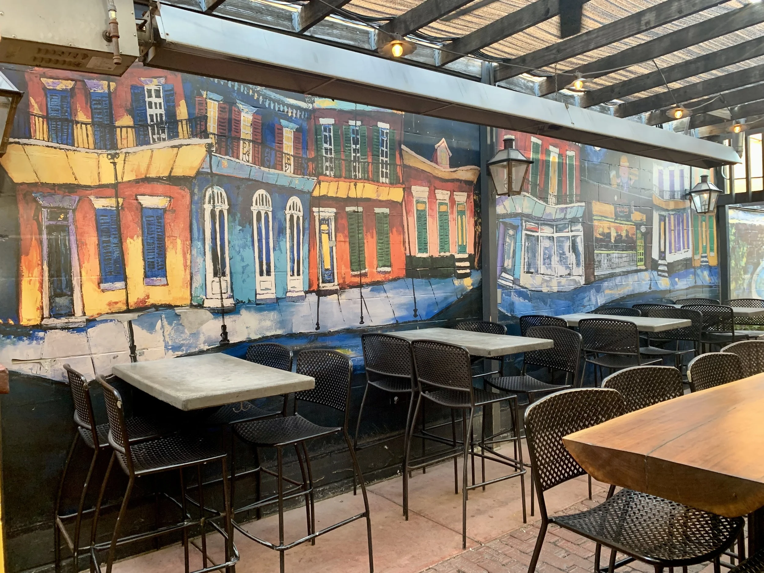 A view of the back patio at Rock-a-Belly Deli, mural created by Phyllis J Garibay-Coon.