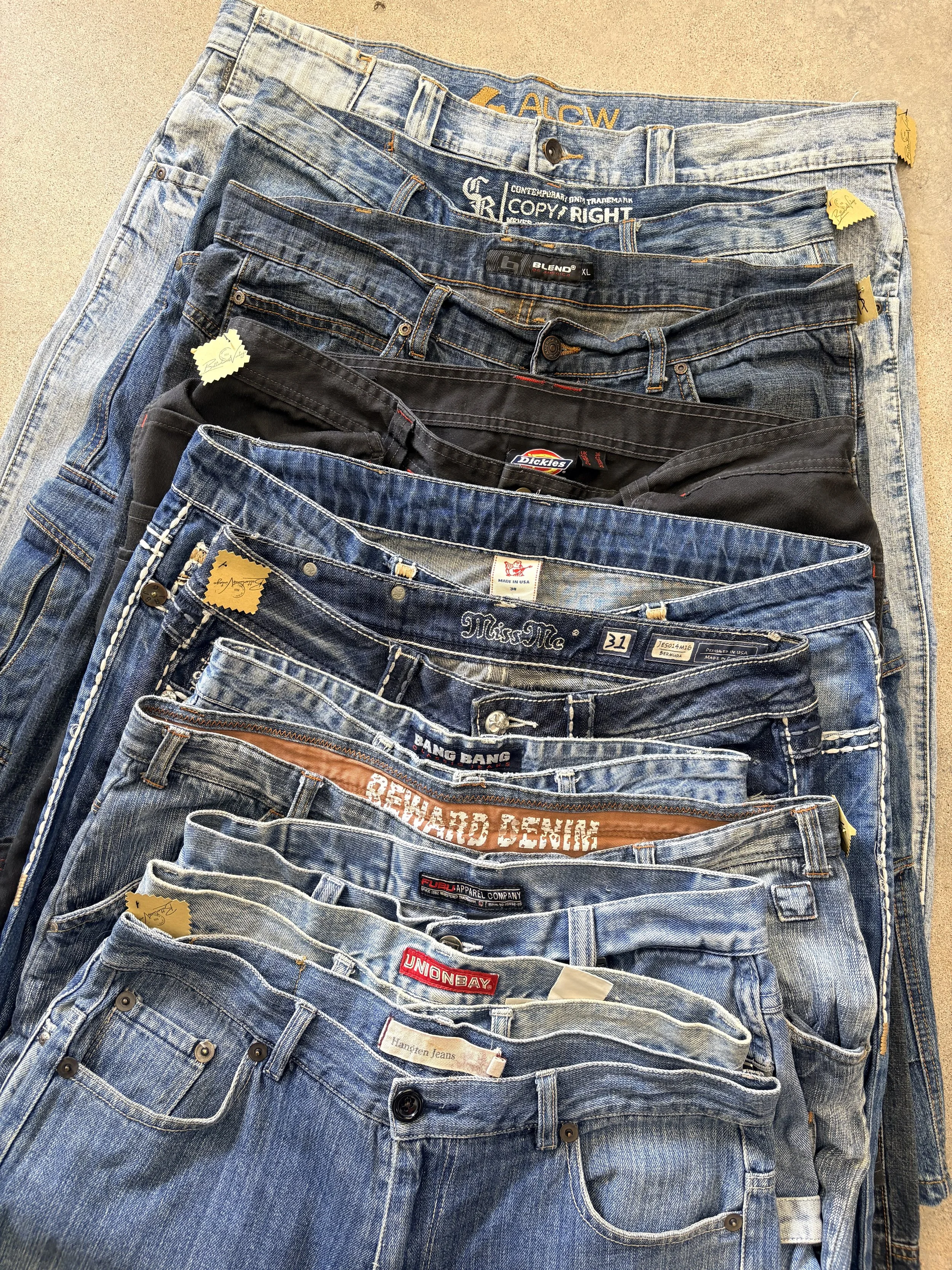 Multiple pairs of jeans stacked in a display at a clothing store.