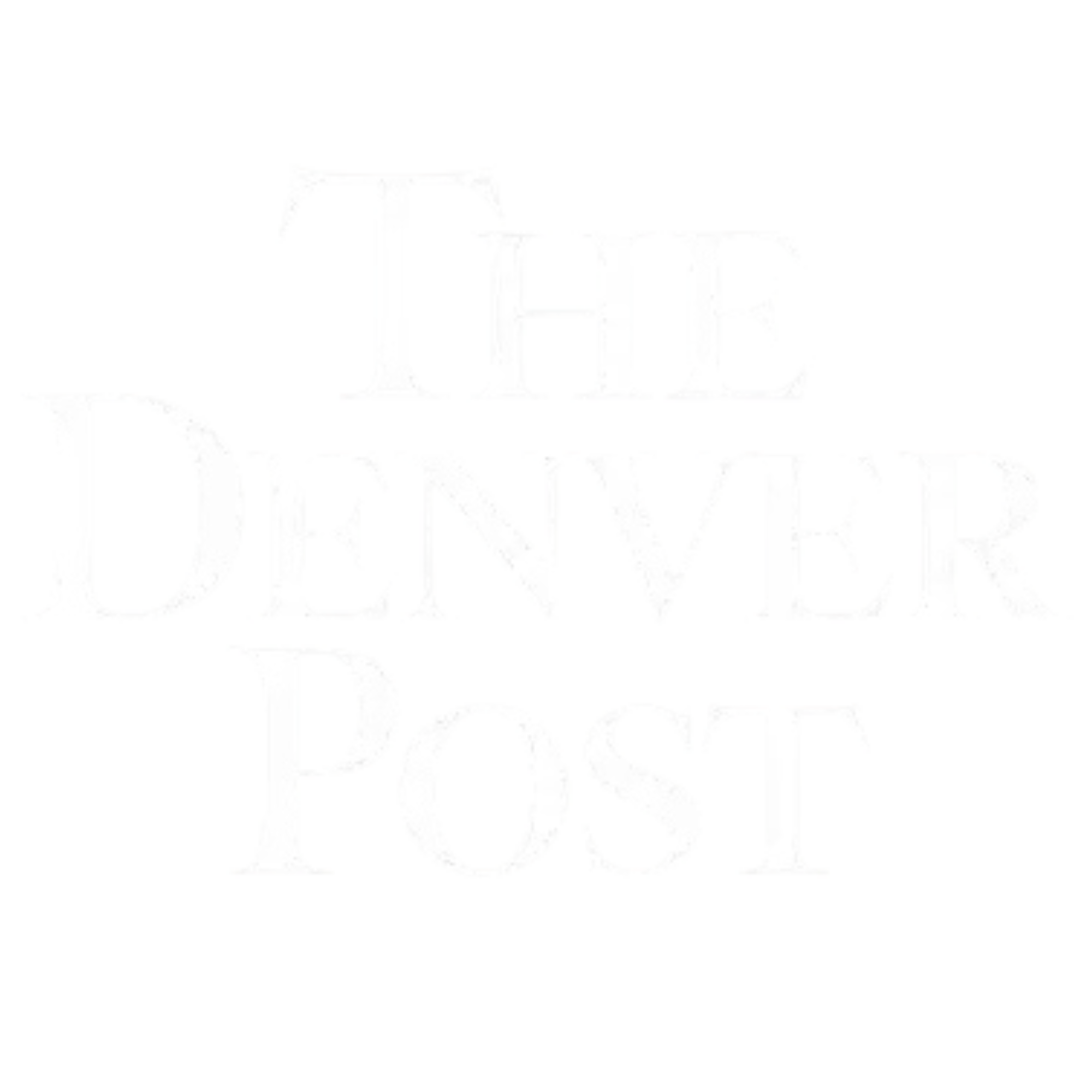 A white sign with text that reads 'Dreams Don't Work Unless You Do' in black letters, placed outdoors in front of a building with trees and a road.