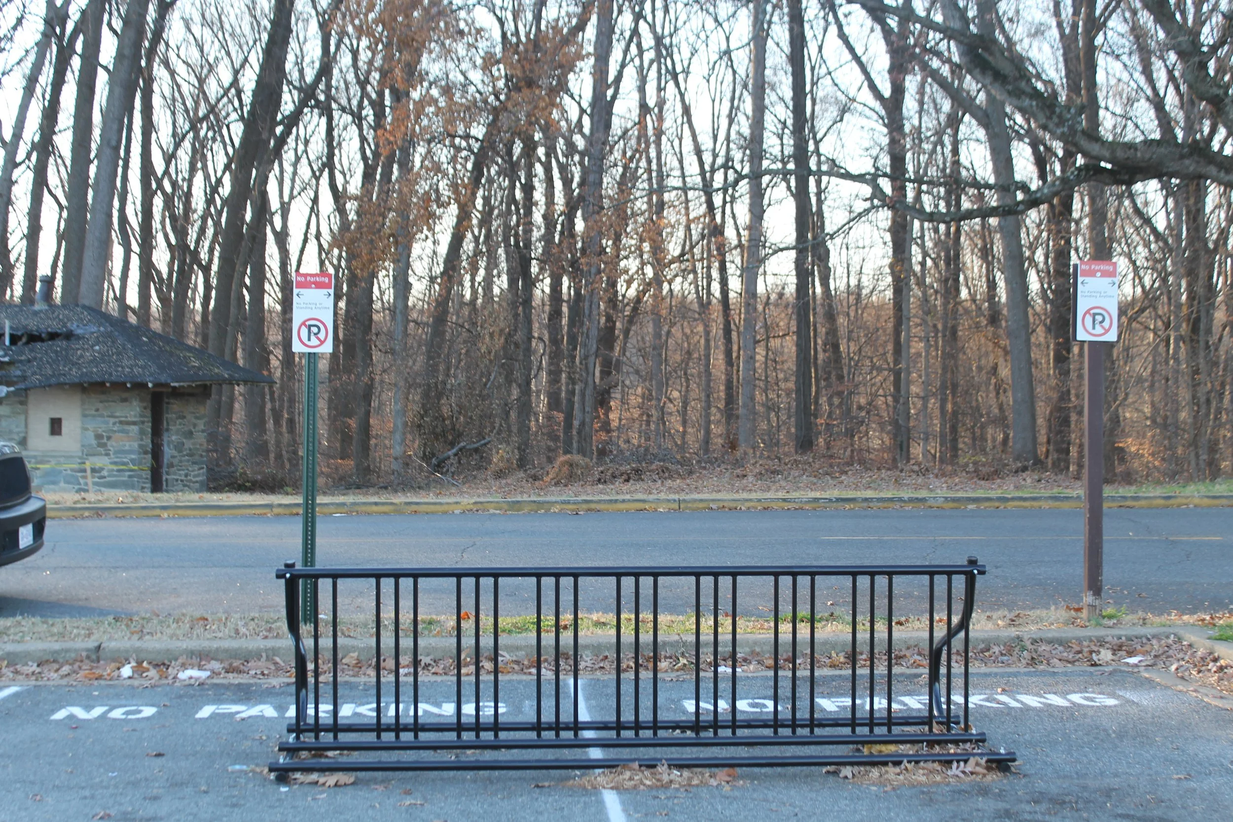 Black, metal bike rack in a parking lot 