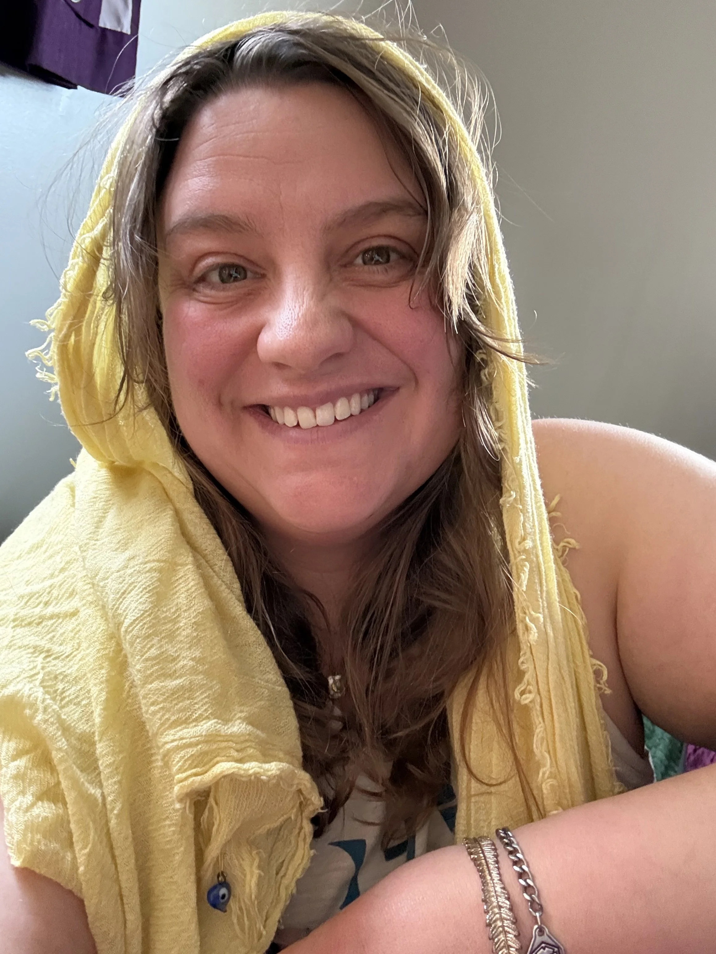 Portrait of a smiling white woman in a yellow scarf