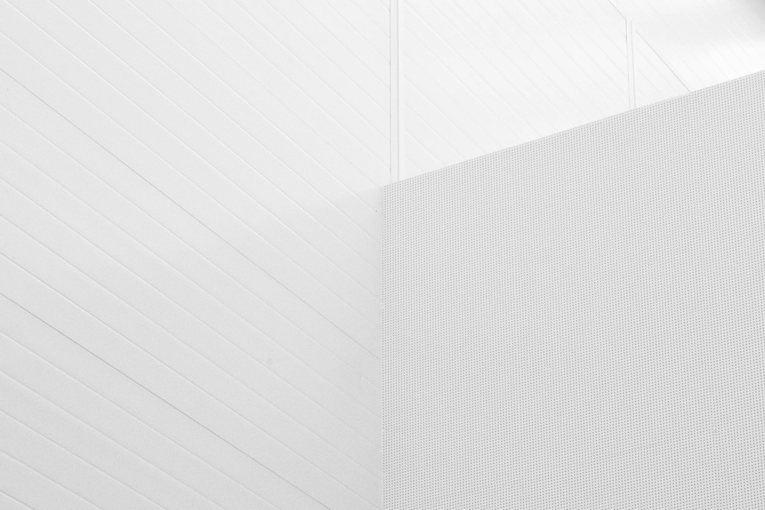 Close-up of a modern, white interior wall with textured and smooth paneling, representing clear communications
