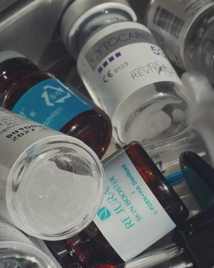 A pile of various medication bottles, including prescription and over-the-counter medicine bottles.