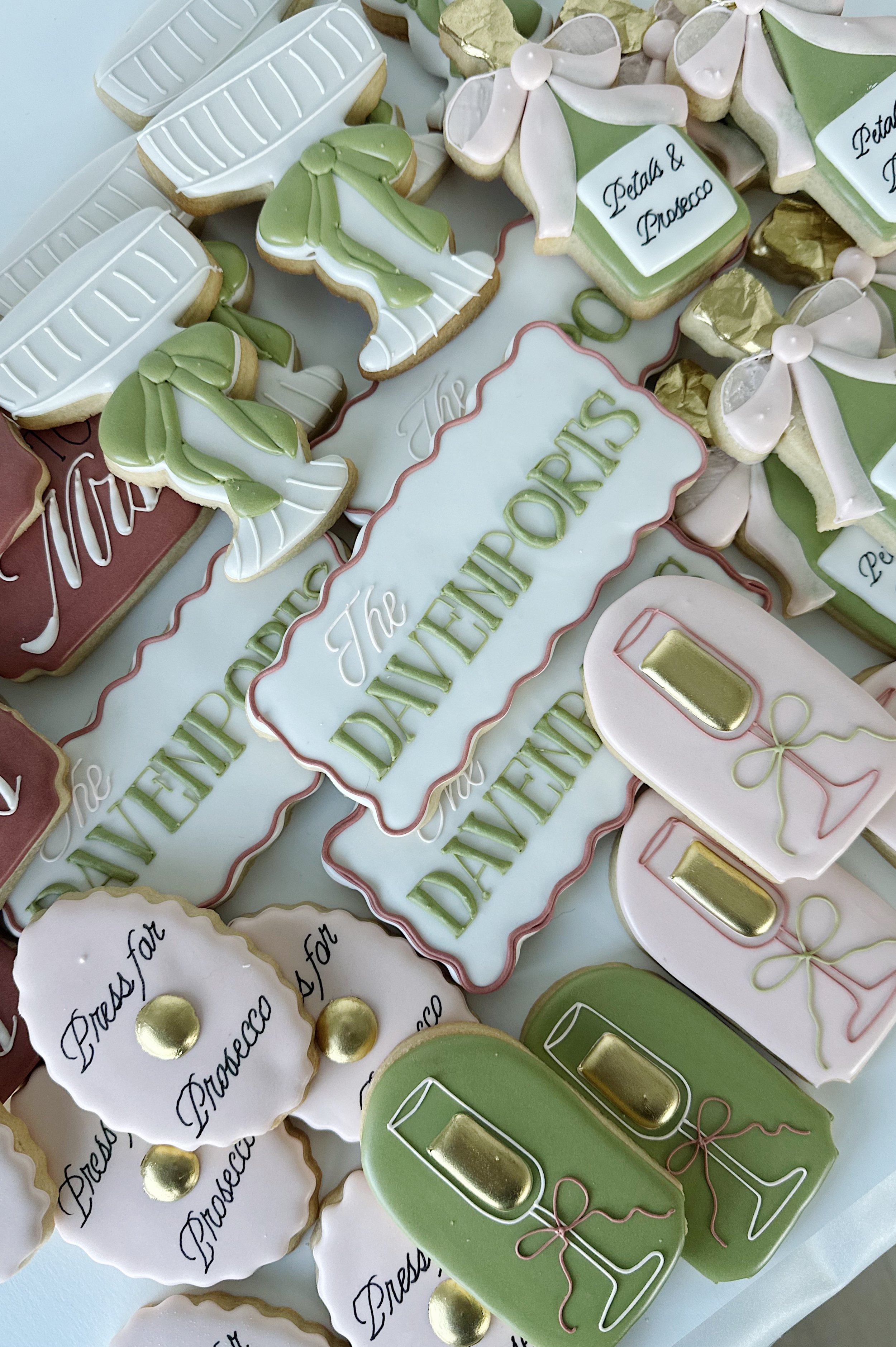 Decorative cookies with champagne glasses, flowers, and the message 'The DAMPERIPS' for a celebration.