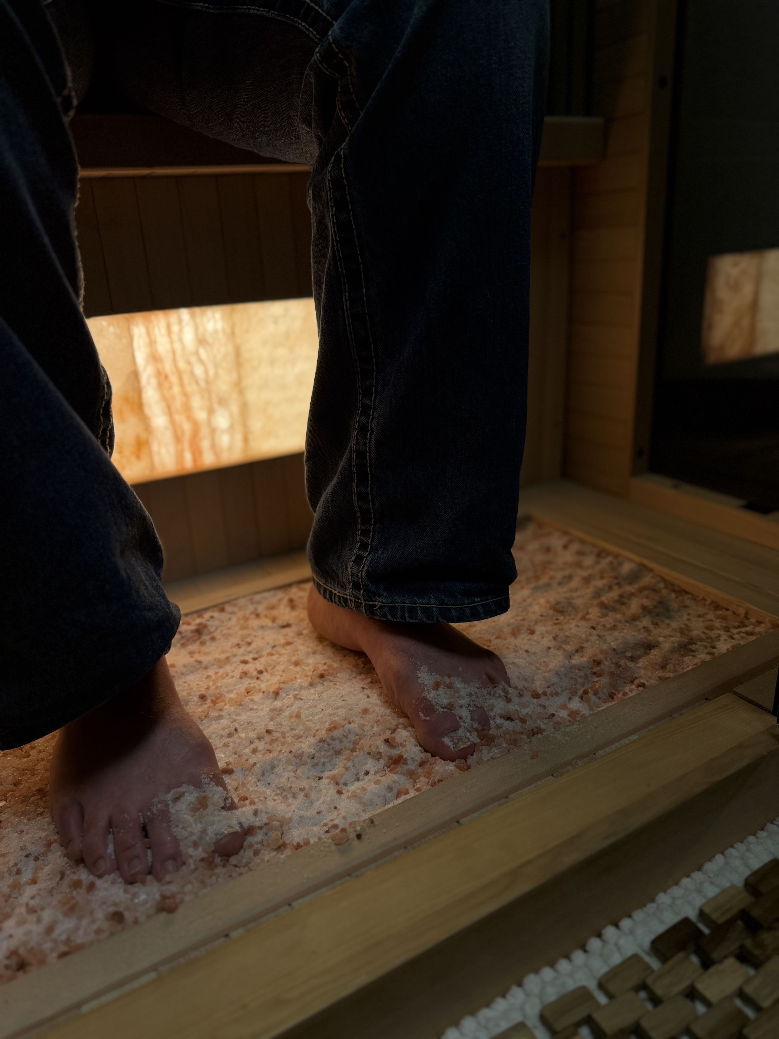 Close up of feet in Salt at the bottom of halotherapy booth.