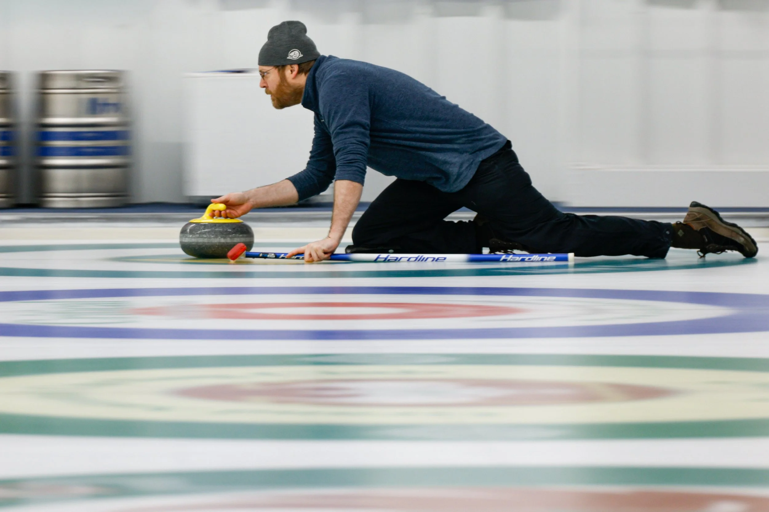 The Empire State Winter Games curling finals took place on Sunday, February, 1, 2026 at the Utica Curling Club. Player captured sliding the rock down towards the target. (Isaac Williams/The Newhouse School)