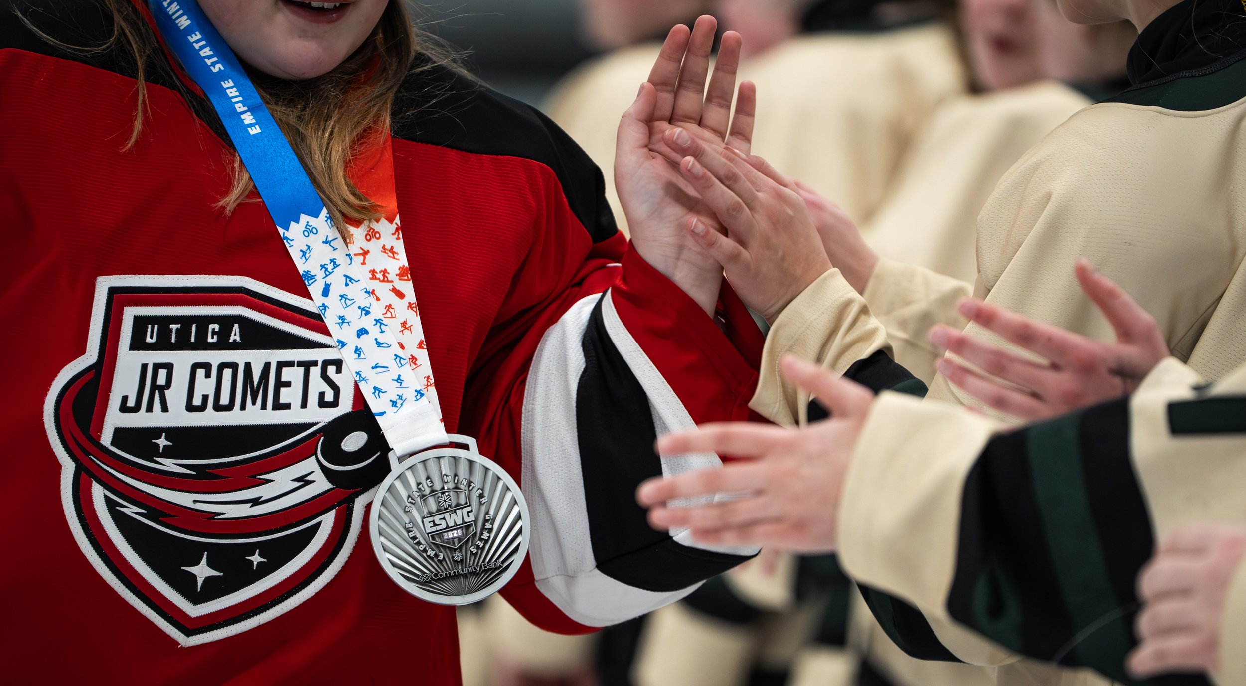 Utica Junior Comets player shakes hands with Adirondack 46ers players after the gold medal game on Feburary 8, 2026 at the Saranac Lake Civic Center in Saranac Lake, NY. (Isaac Williams/The Newhouse School)