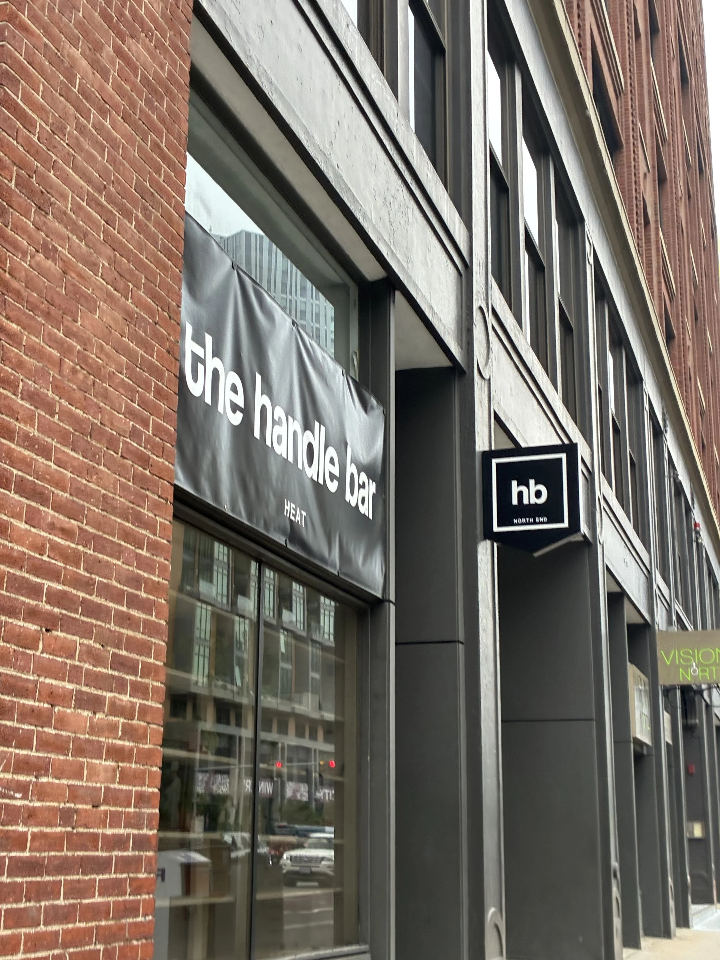 Exterior view of a building with signs for 'the handle bar' bar and 'hb NORTH END'