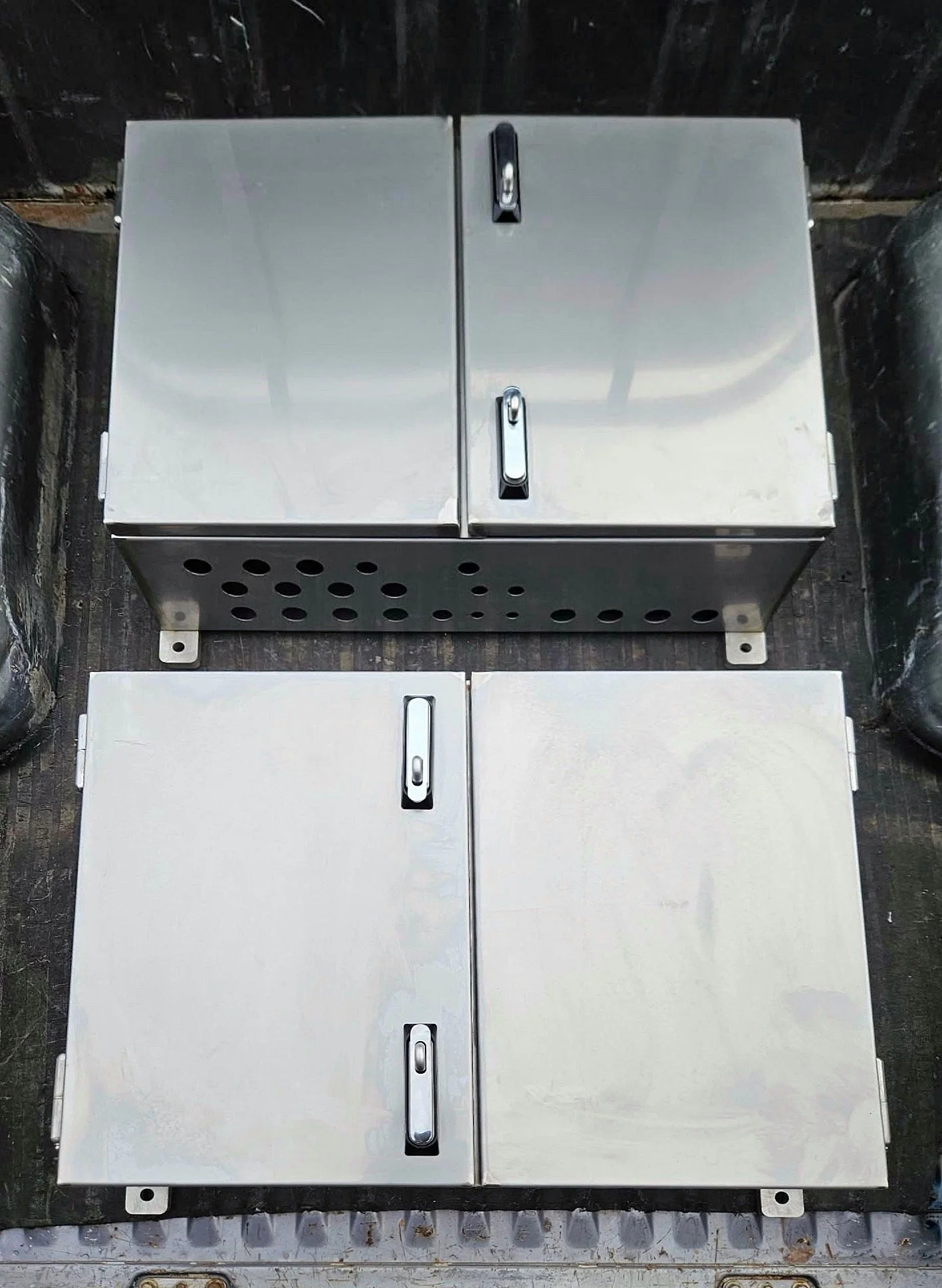 Two metal electrical or utility boxes with handles, mounted side by side on a wall.