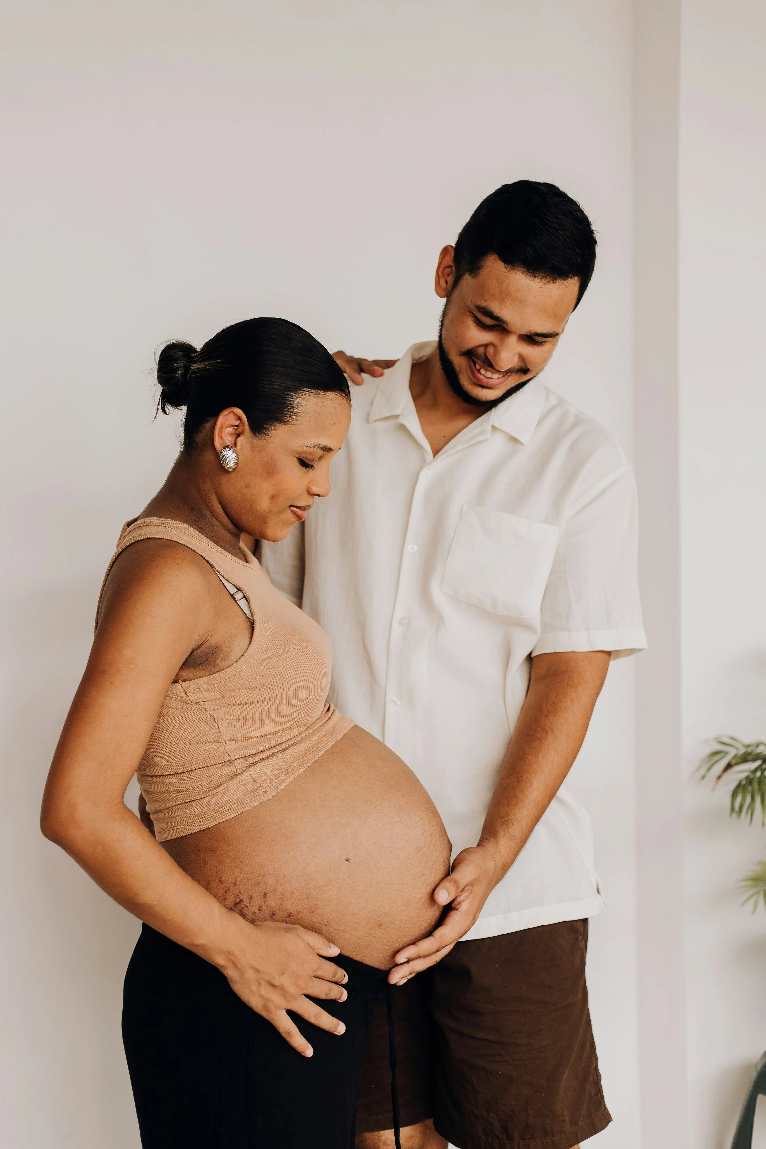Expecting couple lovingly cradling pregnant belly, supported by Om Baby birth doula services in Los Angeles.
