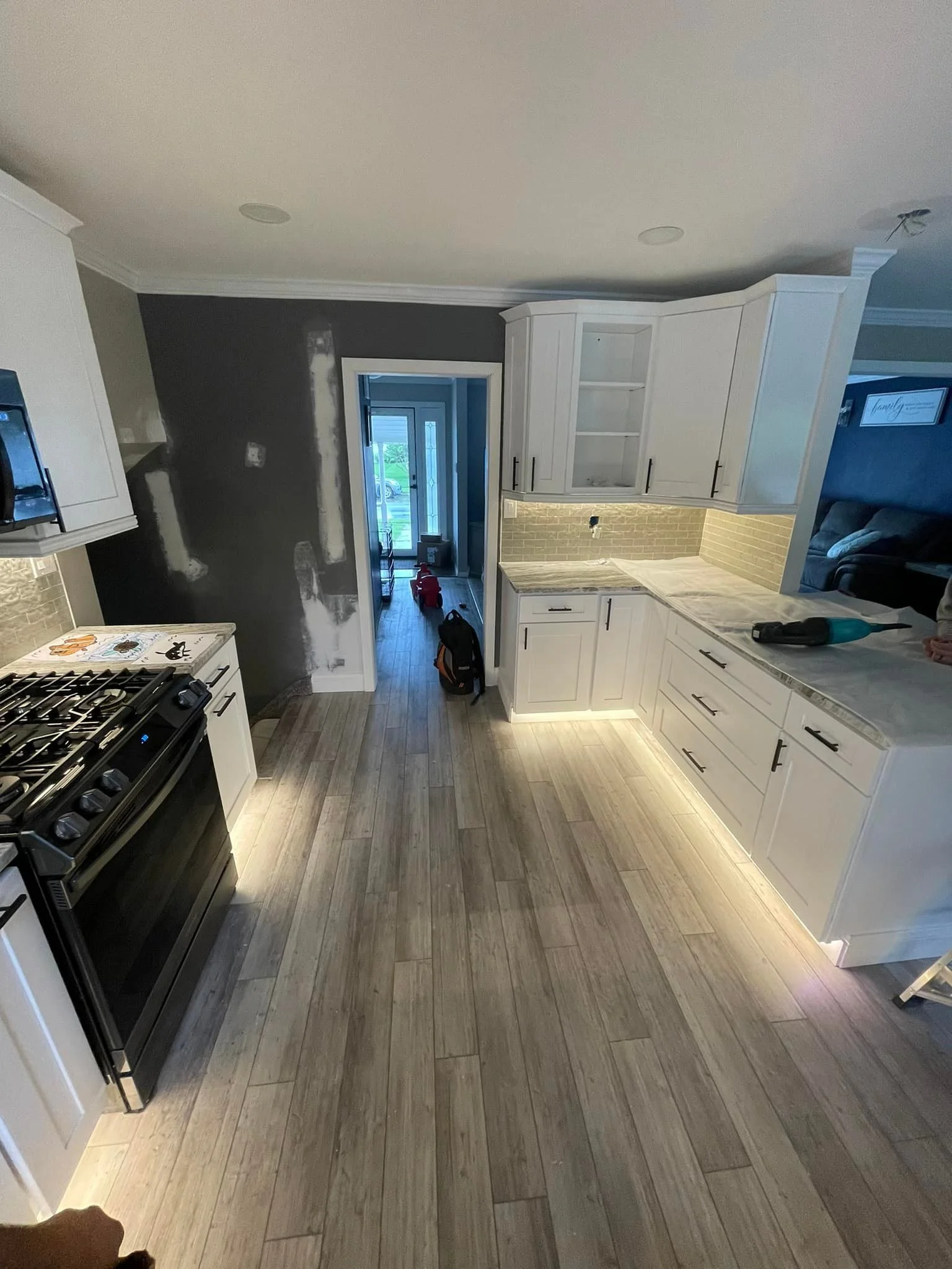 Kitchen under renovation with white cabinets, a stove, and unfinished walls.