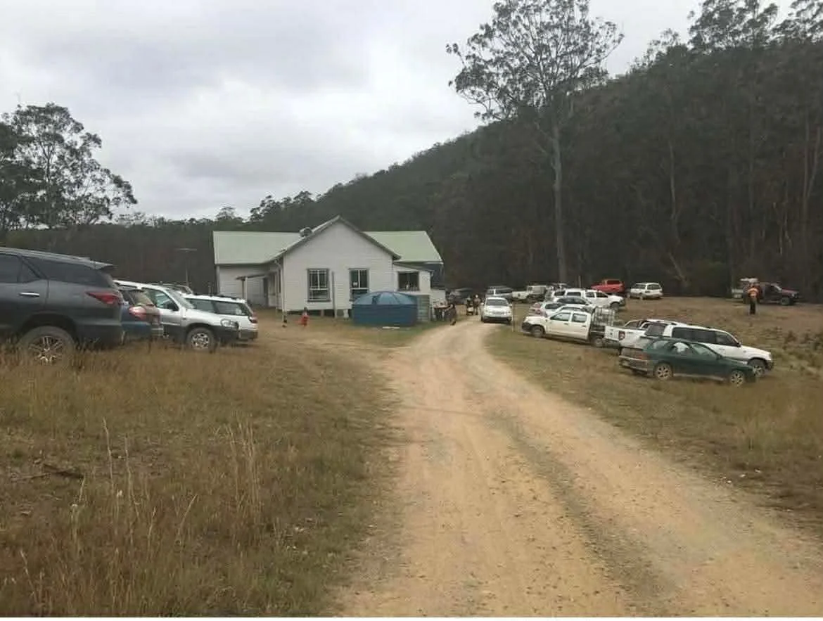 Vehicles and visitors gathered around Little Plain Hall and its grounds