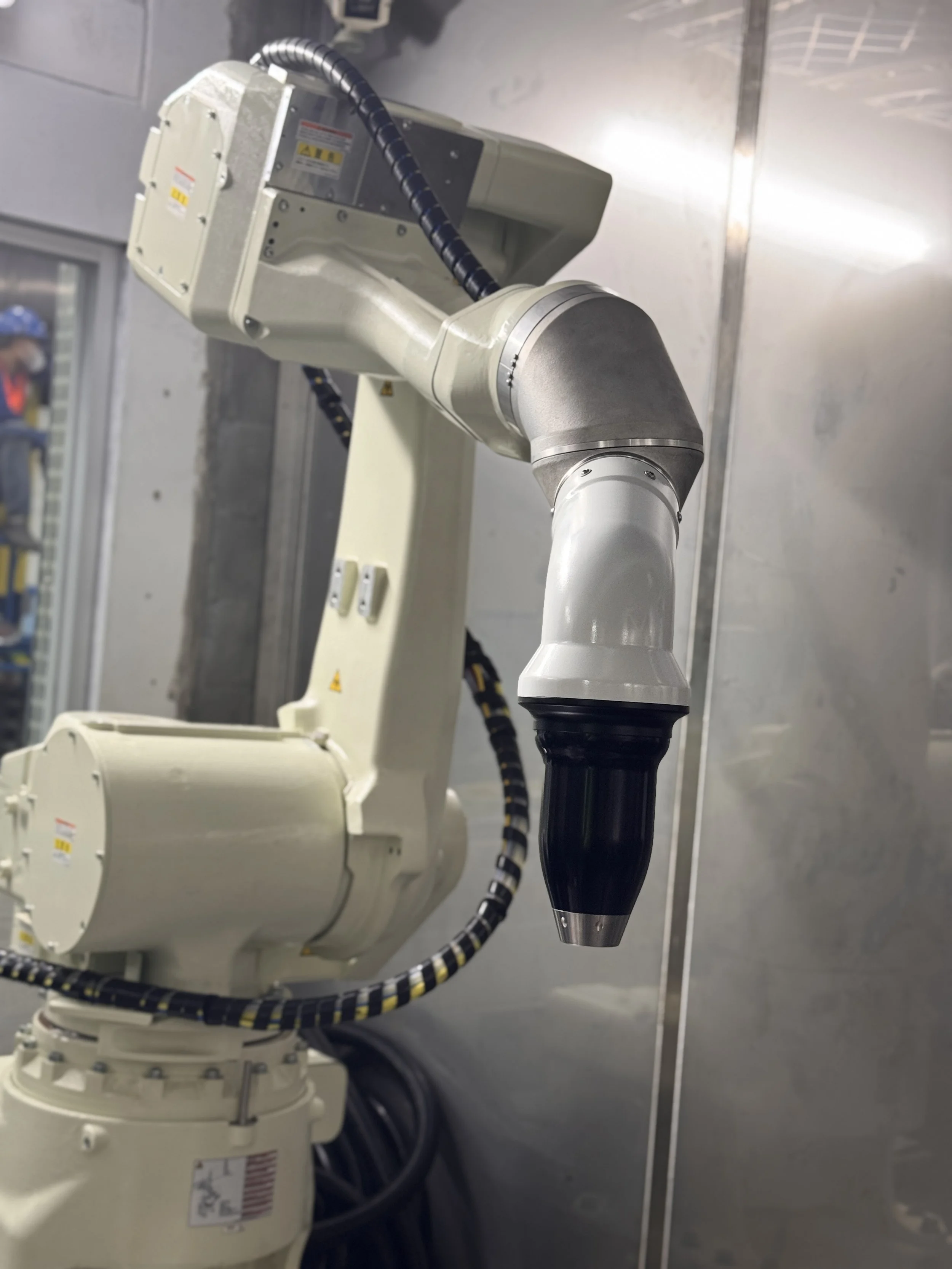 A painting robot in an industrial setting, with a close-up view of the high rotary atomizer Durr EcoBell 2.