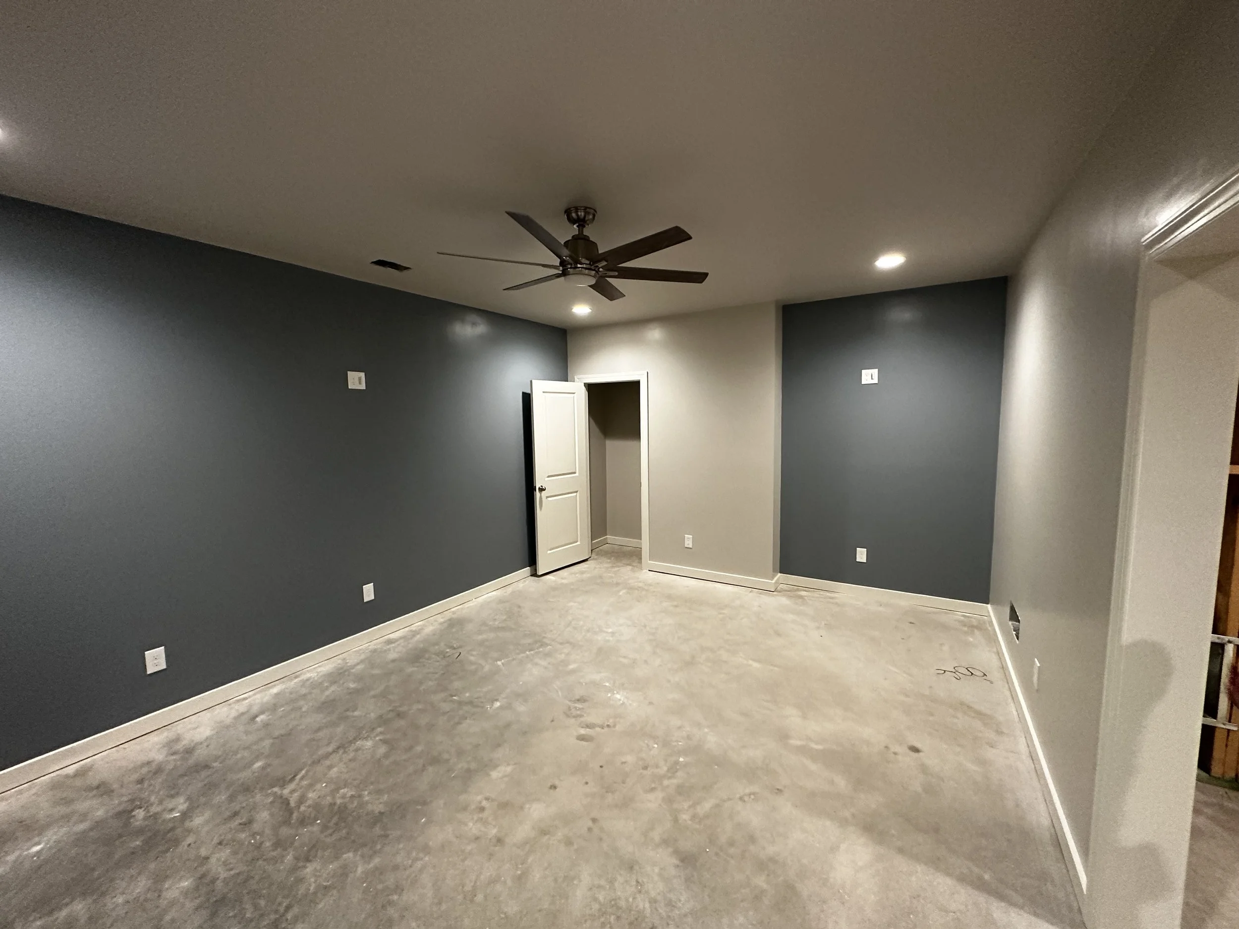 Empty room with blue and gray painted walls, tile flooring, ceiling fan, and recessed lighting.