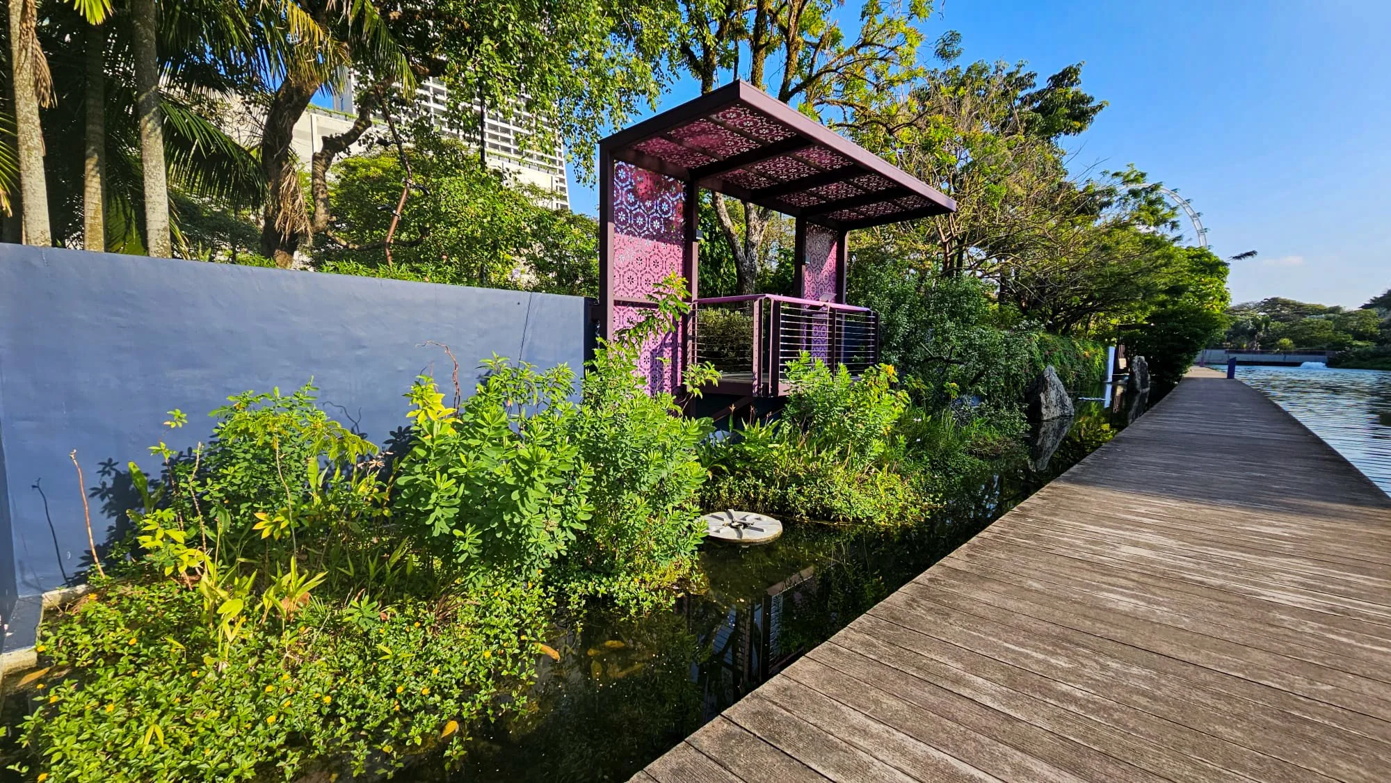 Waterfront garden with a small pavilion, boardwalk and layered planting.