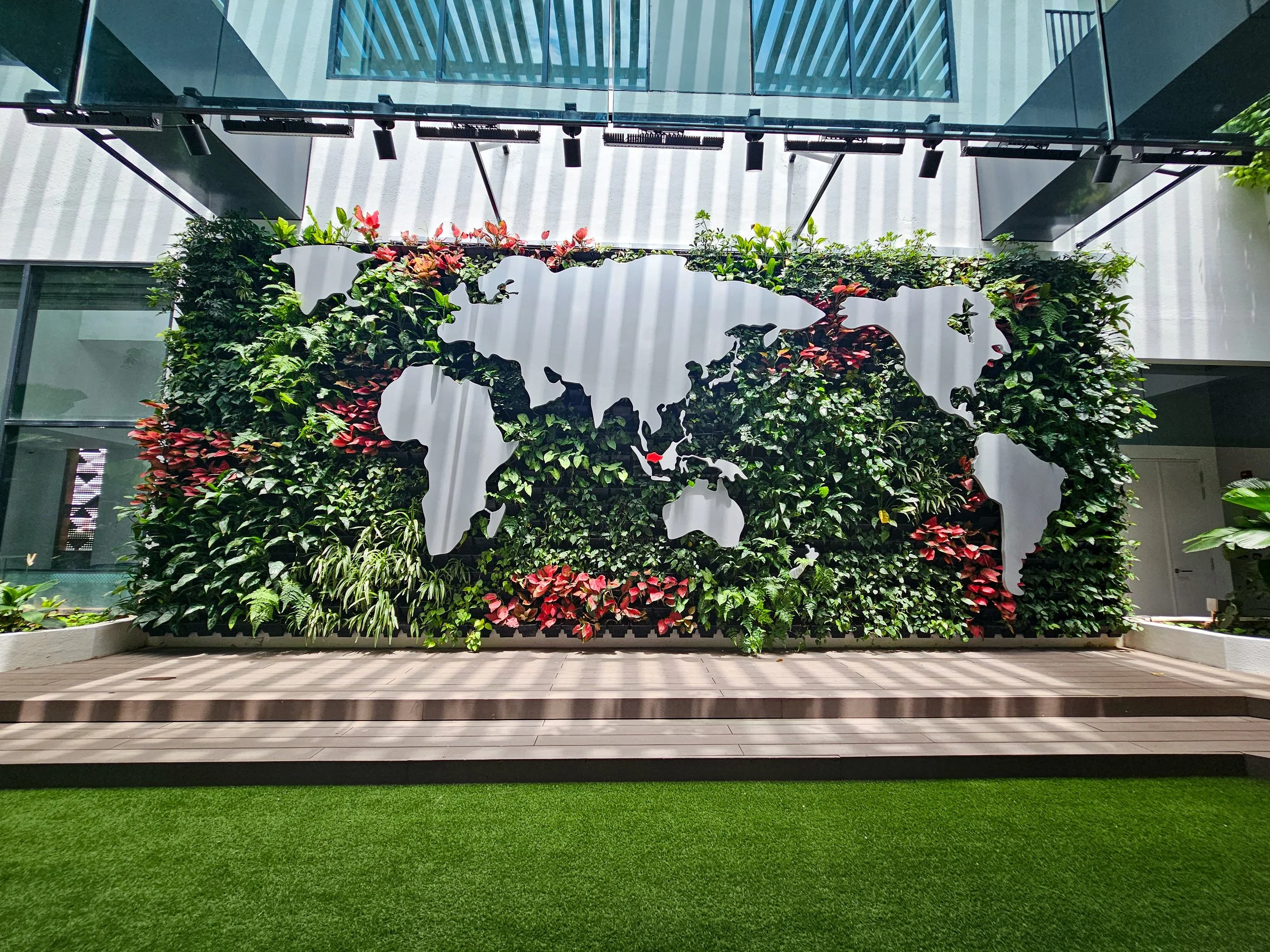 Indoor area with artificial grass turf and a green wall.